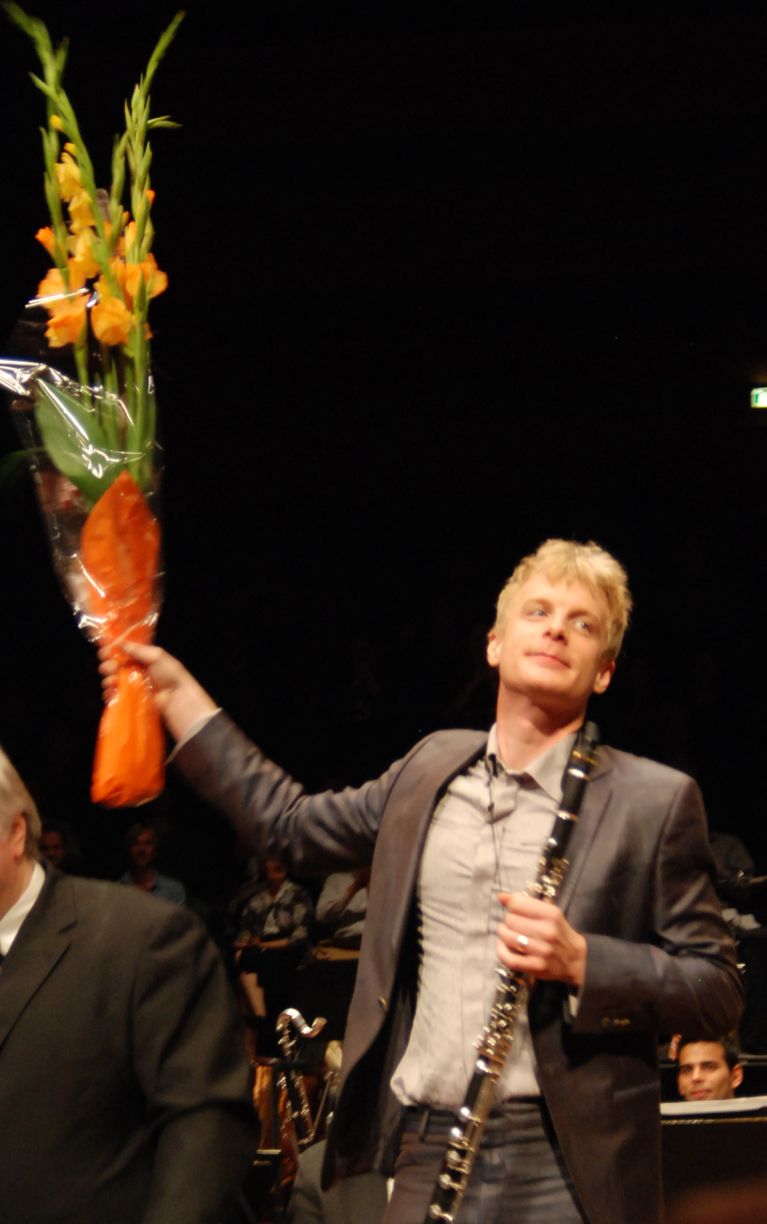 Martin Fröst med bassettklarinett och blommor.