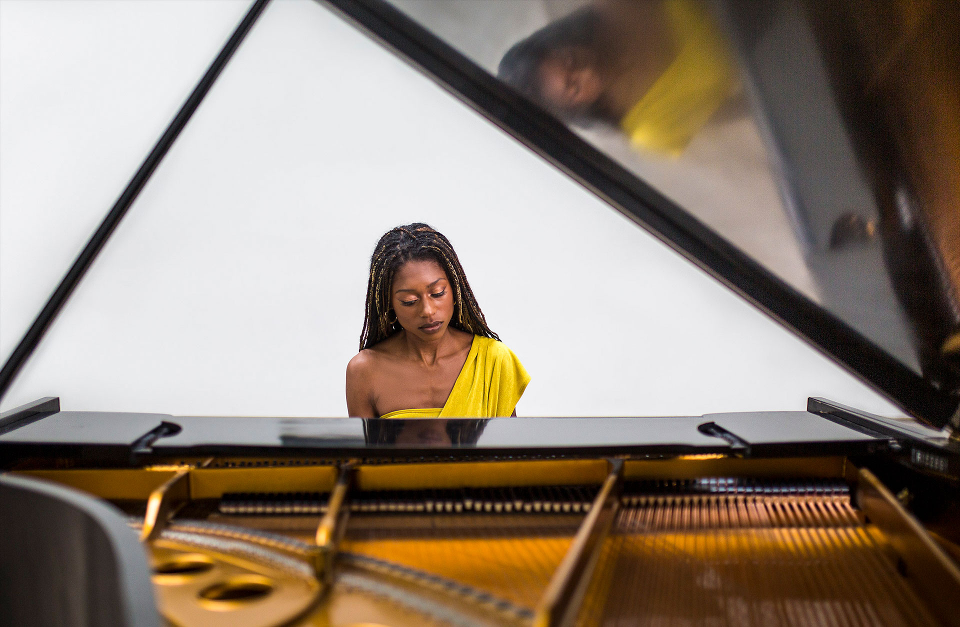 Pianisten Sata Kanneh Mason tittar ner på flygelns tangenter.