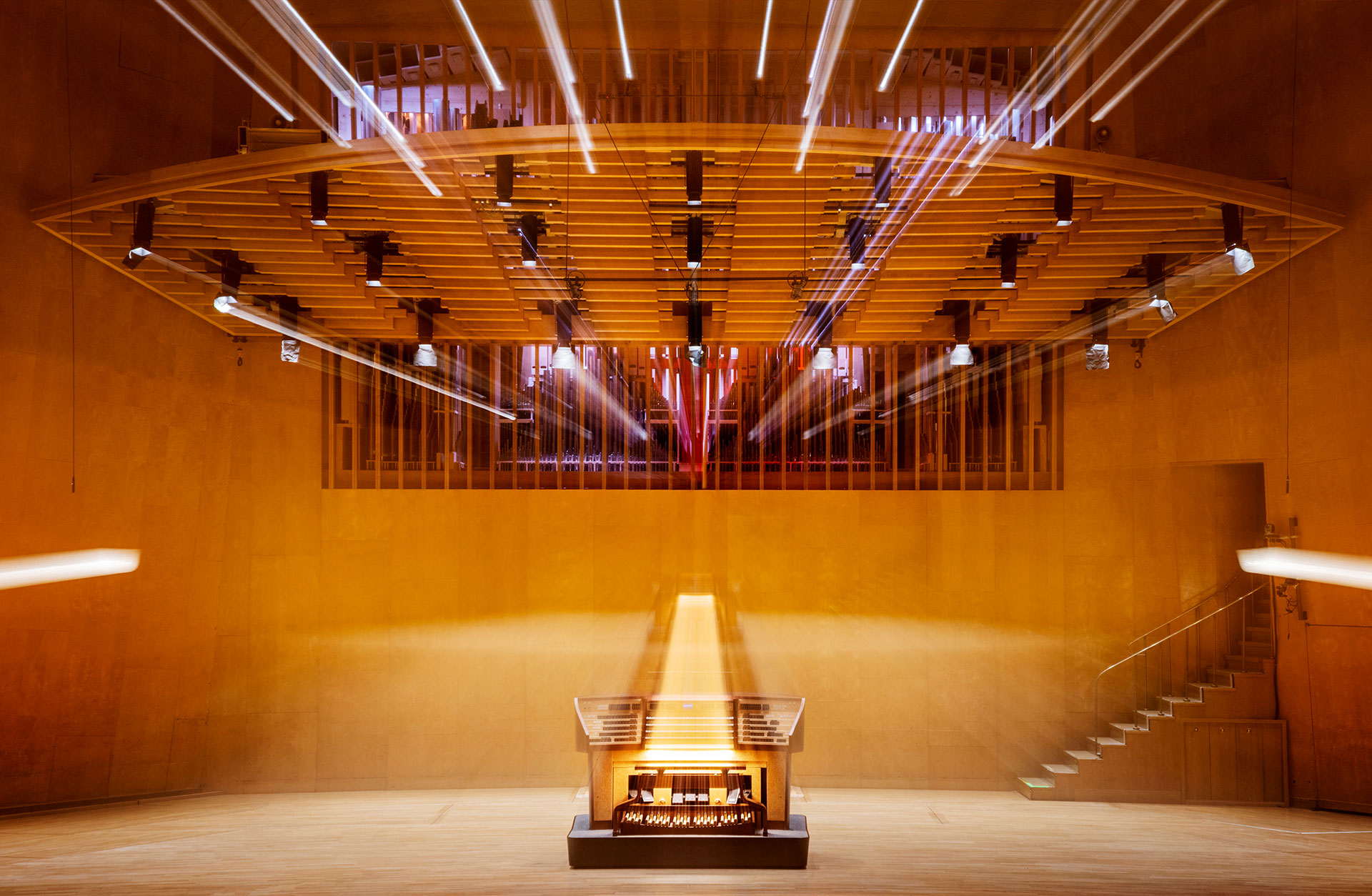 Orgelns spelbord står centrerad på scenen i Stora salen, i bakväggen syns orgelpiporna skymta mellan lameller i väggen.