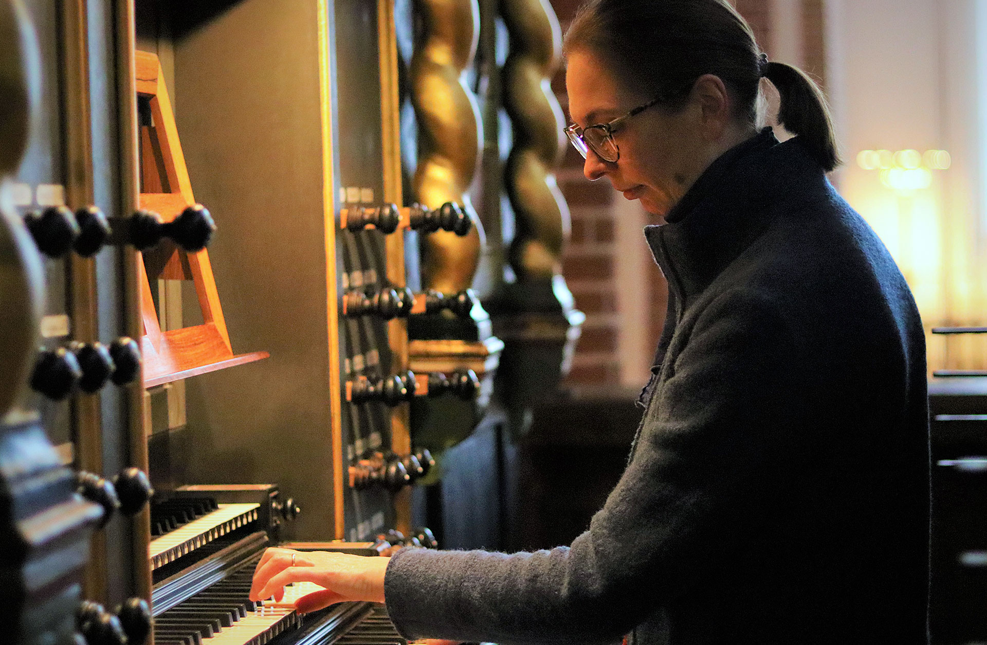 Organisten Bine Bryndolf vid orgelns spelbord.