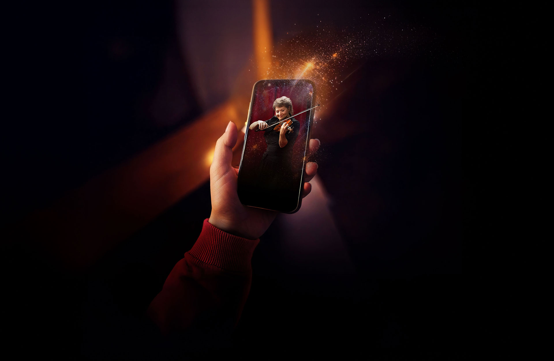 Violinist kommer ur en telefon som hålls av en hand.