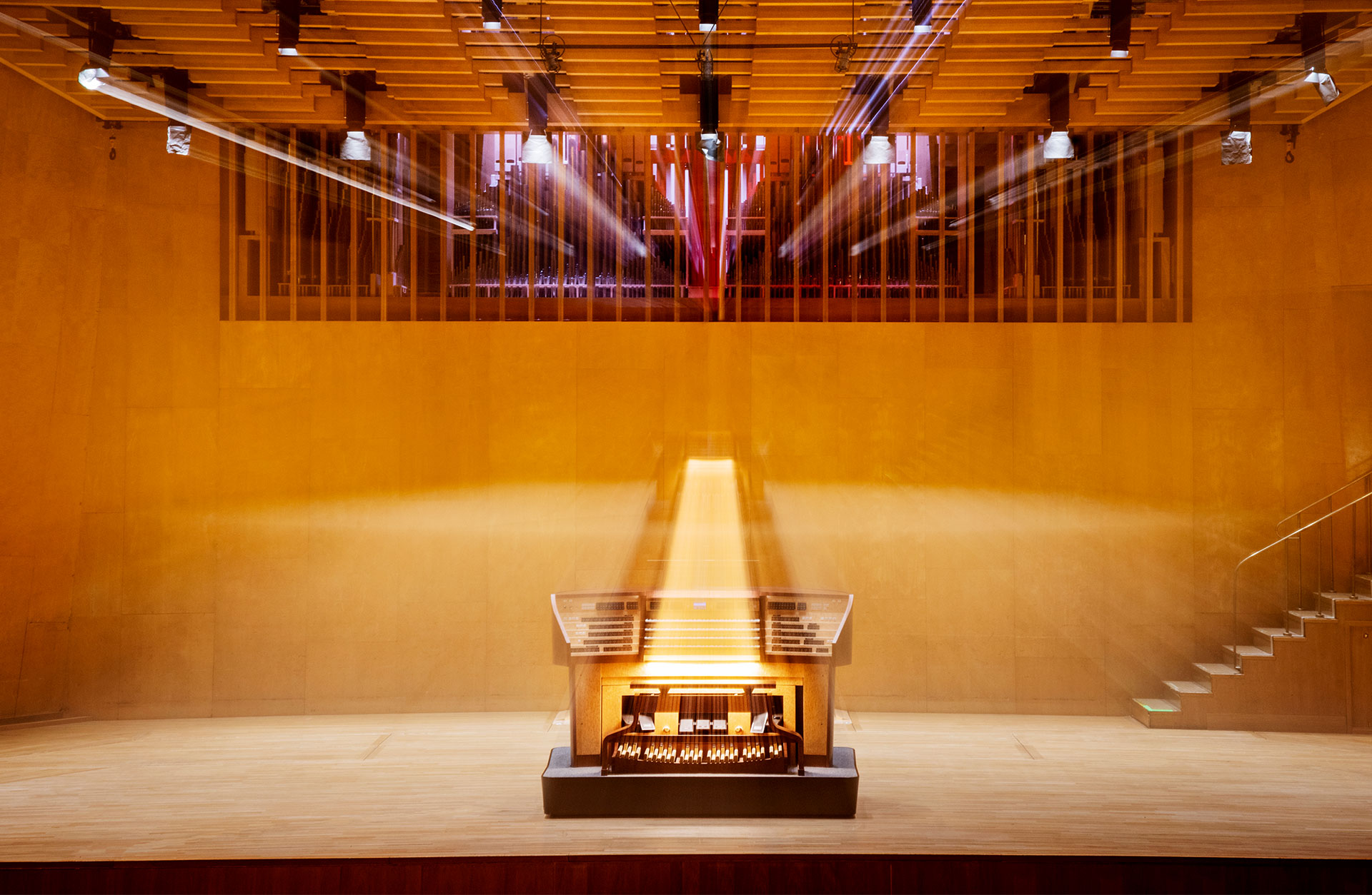 Konserthusets orgels spelbord fotad på podiet med ett sken kring sig.