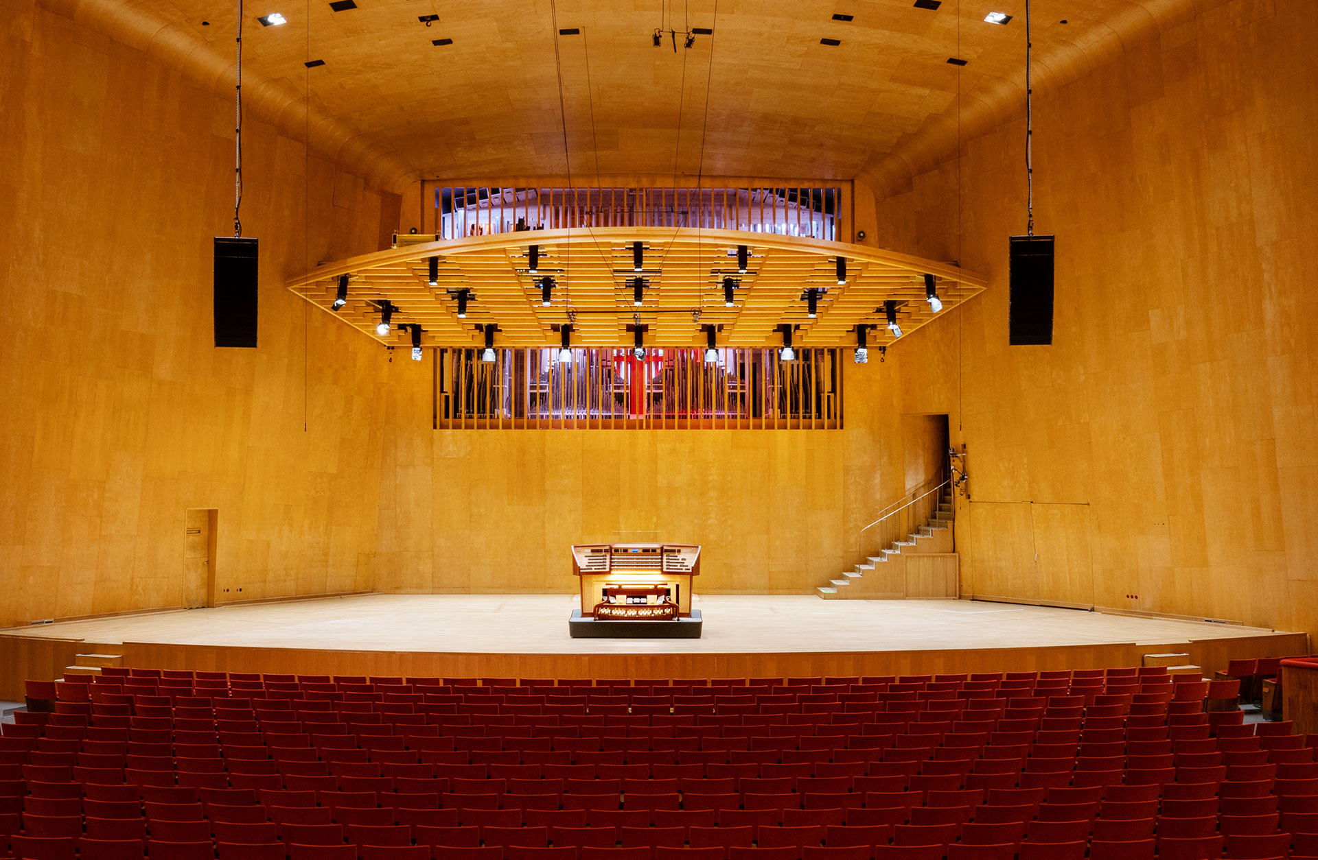 Vy över scenen i Stora salen med orgelns spelbord vid scenkanten och i fonden syns öppningar med orgelpipor bakom.