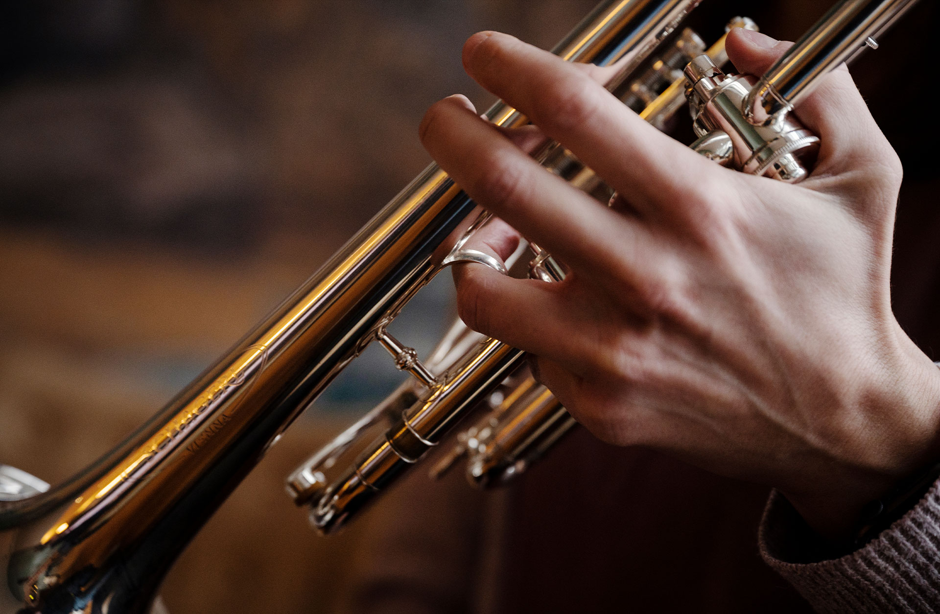 Urškas hand i närbild håller i en trumpet.