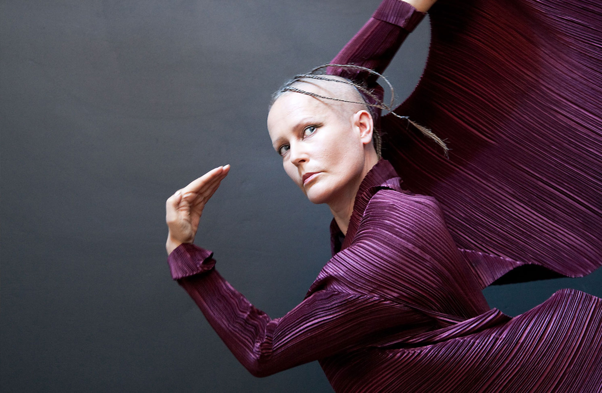 Dansaren Virpi Phakinen i lila scenklädsel, i suggestiv pose.
