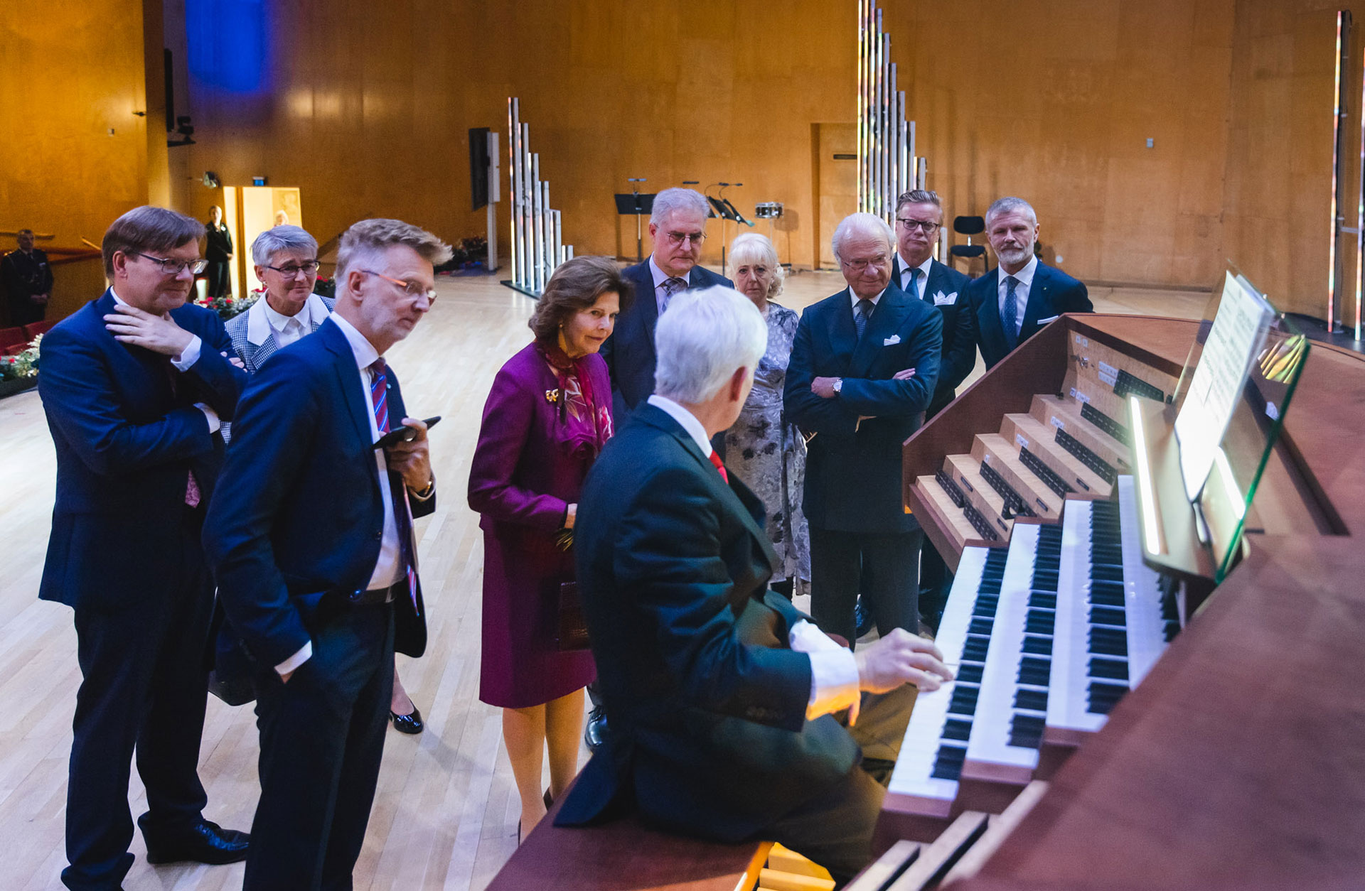 Kungaparet på scenen tillsammans med grupp nyfikna som tittar närmare på orgeln.