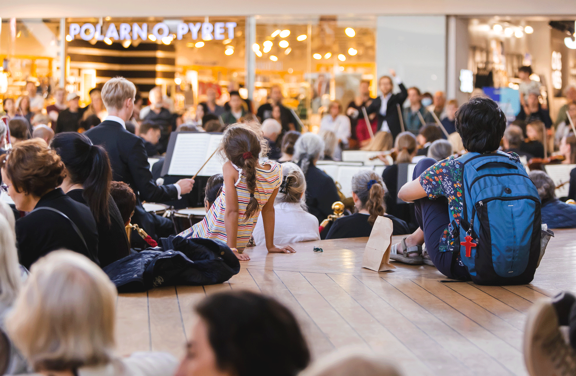 Publik i förgrunden när Göteborgs Symfoniker spelar på köpcentrumet Frölunda torg