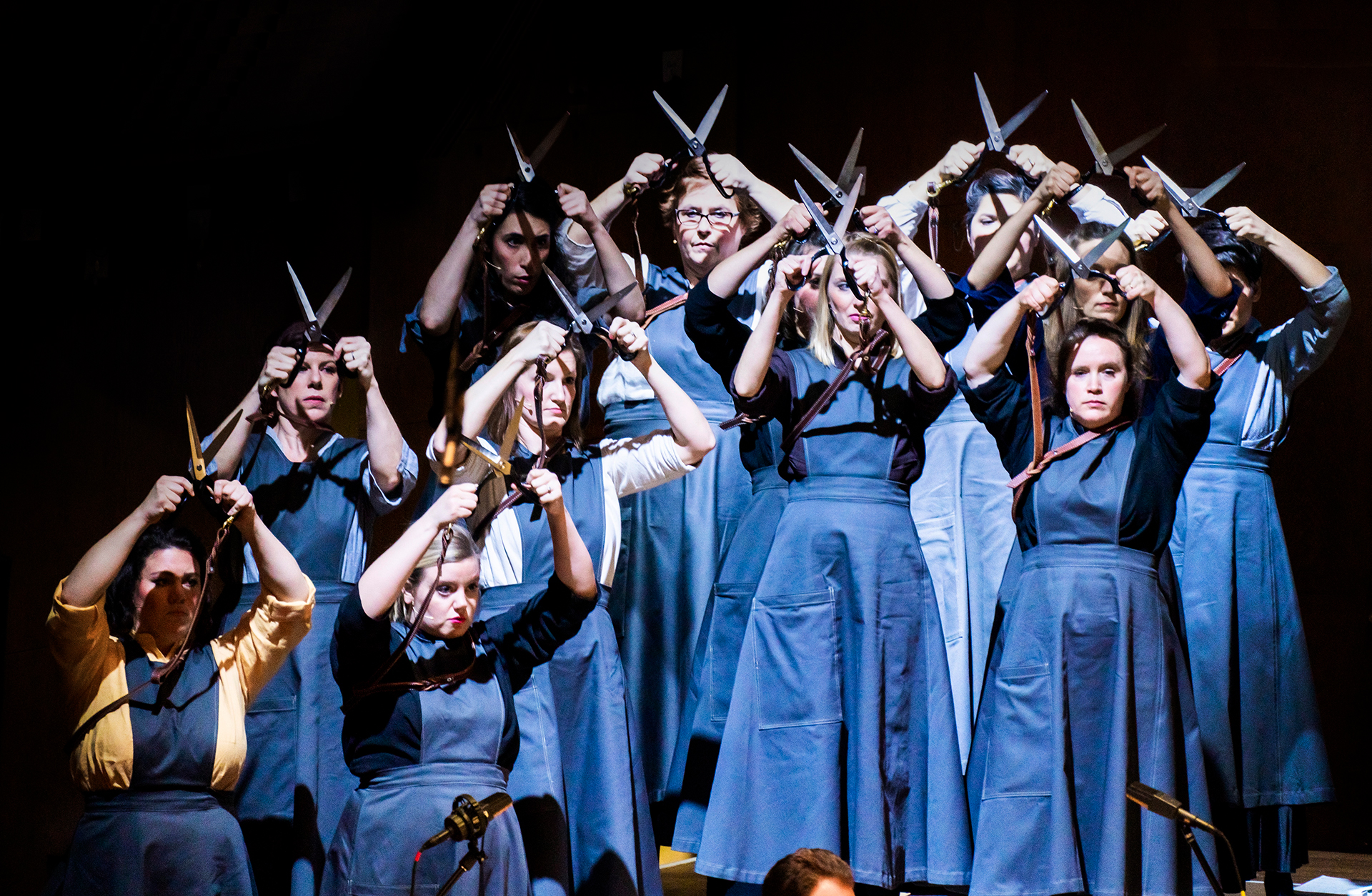 kvinnor som står och håller saxar ovanför huvudet