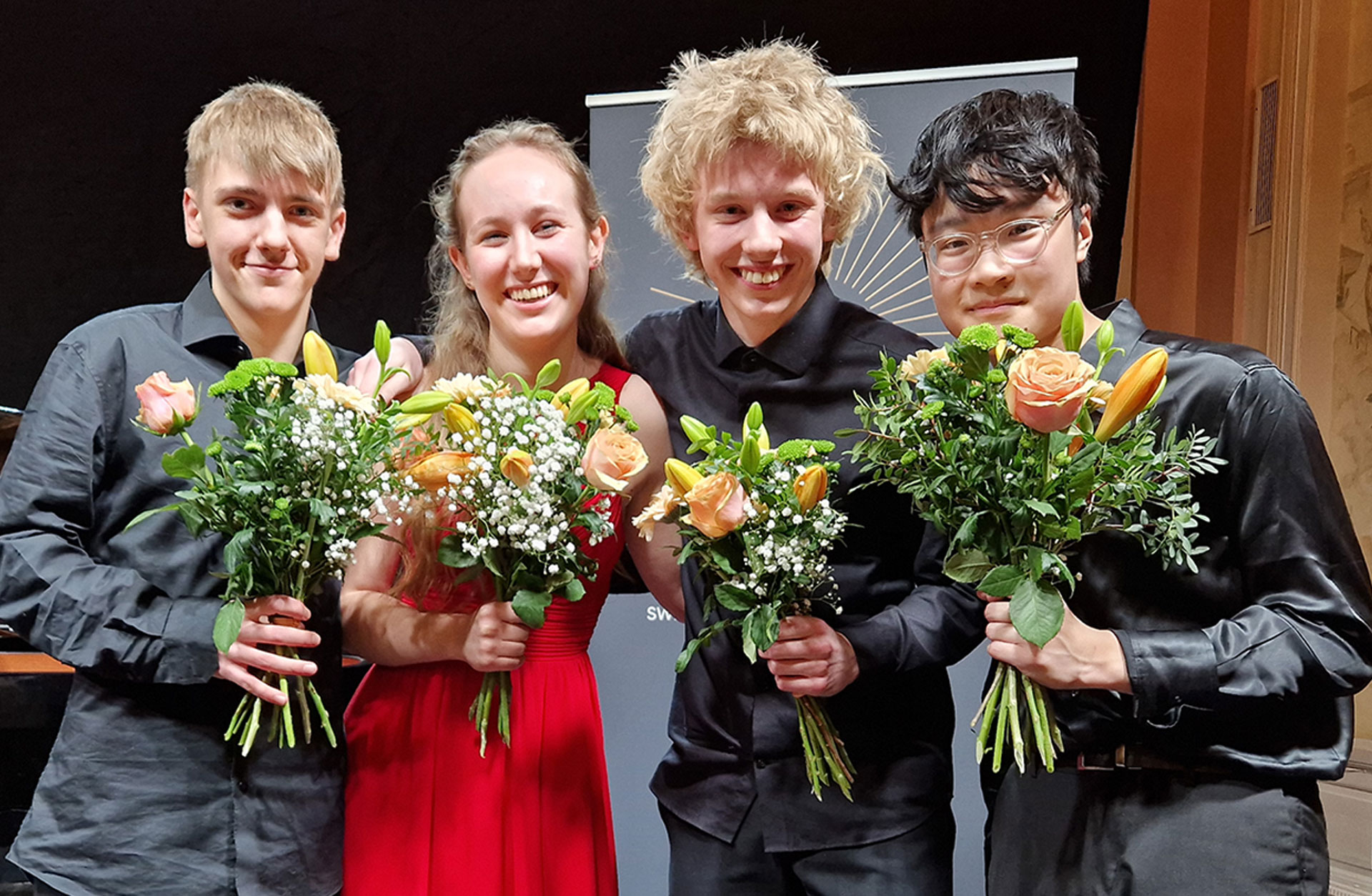 Polstjärneprisets fyra glada finalister med blommor i händerna.