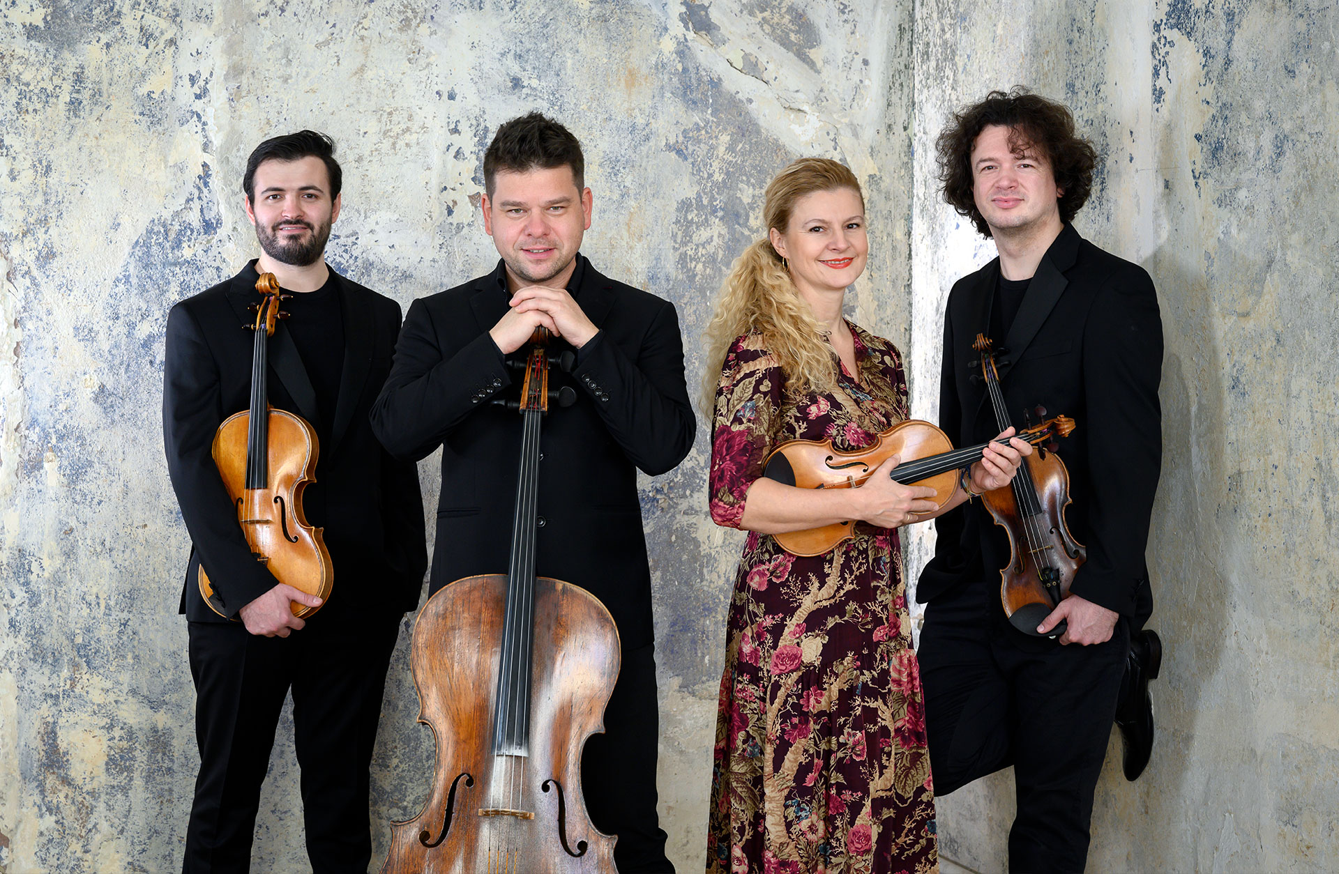 Pavel Haas Quartet med instrument i handen, lutandes mot en marmorvägg.