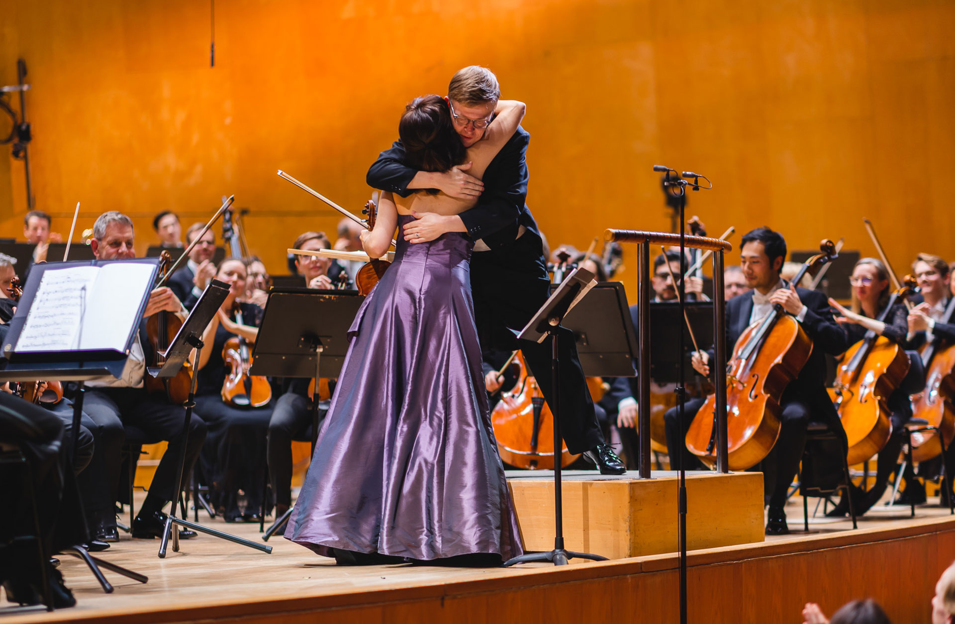 Violinsolisten Ava Bahari kramar dirigenten Pekka Kussisto efter konserten, i bakgrunden syns orkestern.