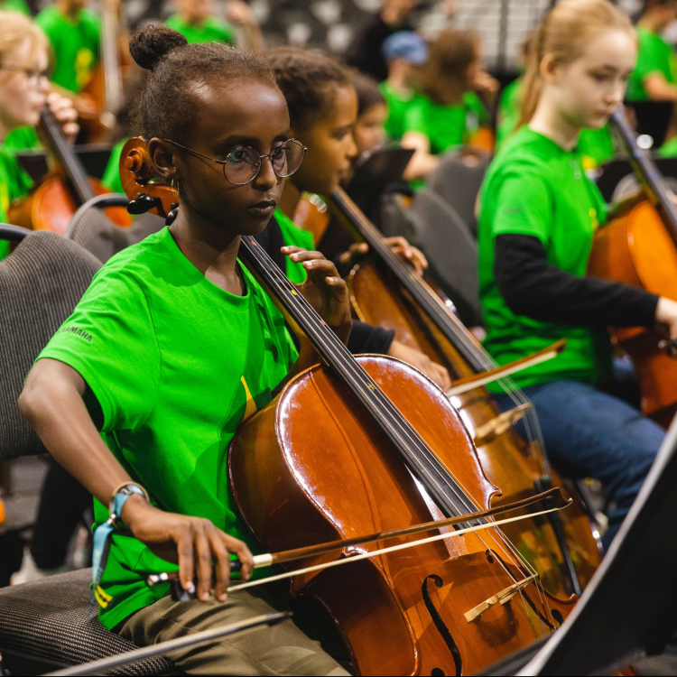 Koncentrerade barn spelar cello