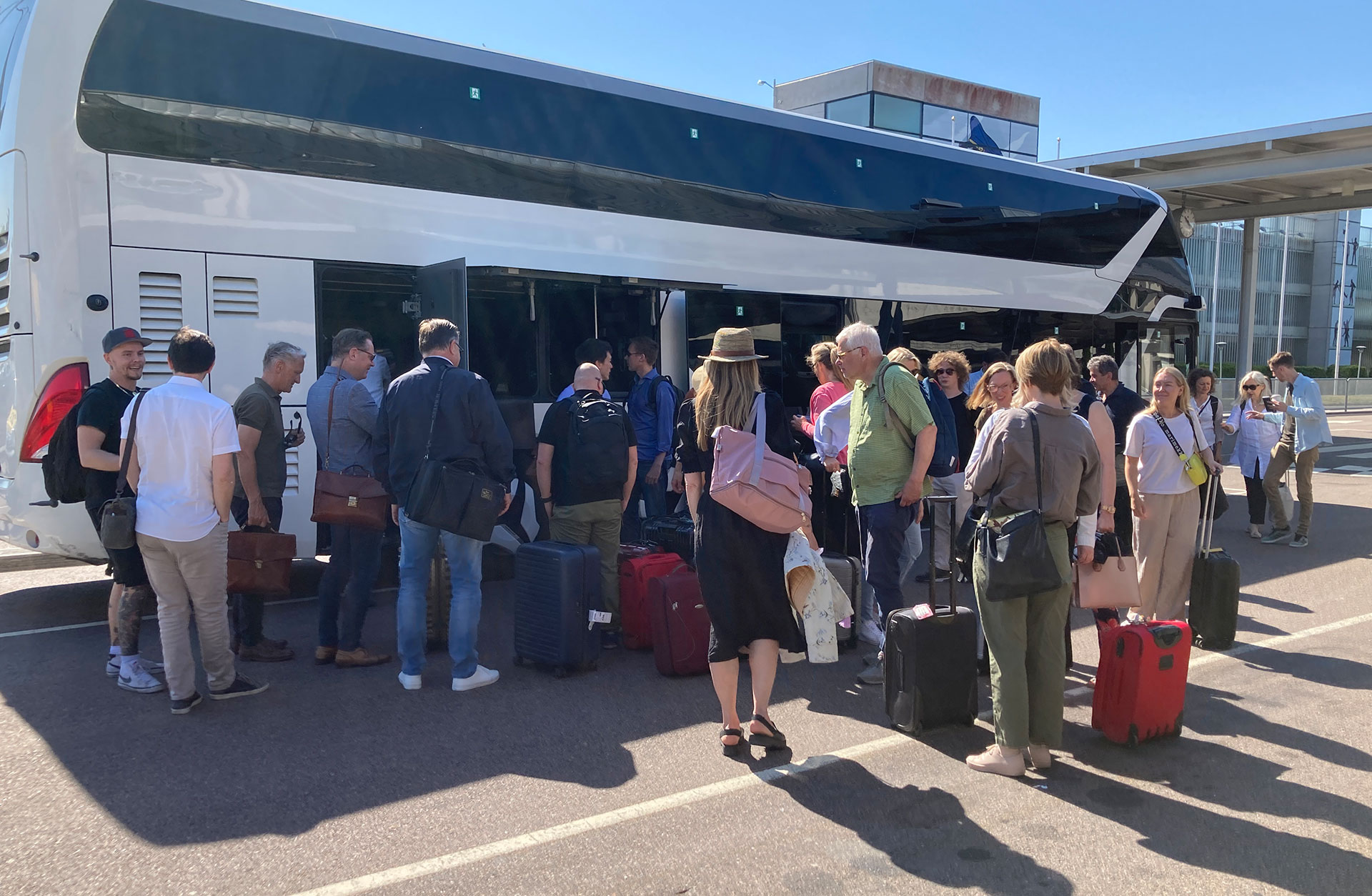En grupp ur Göteborgs Symfoniker tar sina väskor ur bussen bagage.