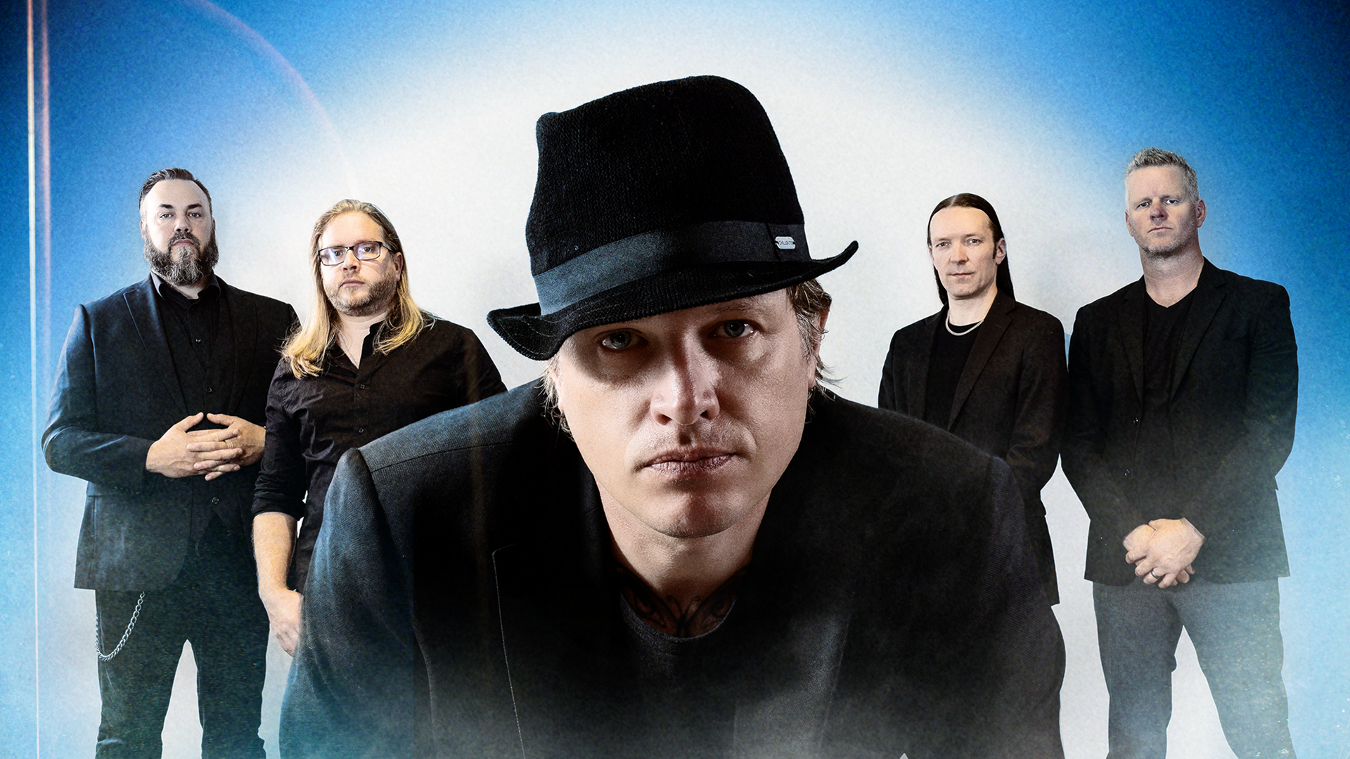 Fyra män i mörka kavajen, mannen främst i bild har en hatt på huvudet