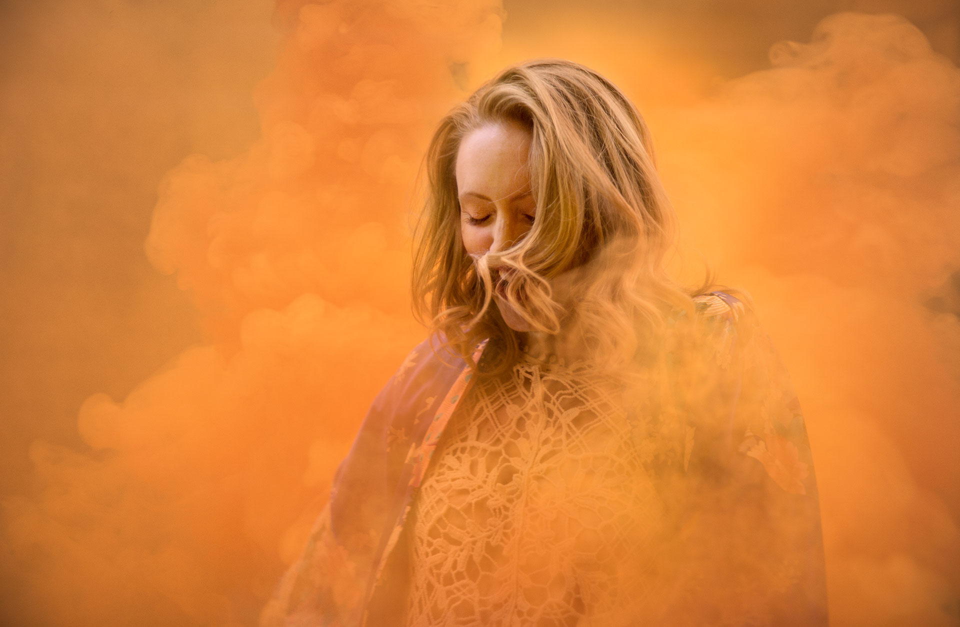 Kvinna i organefärgad rökridå.