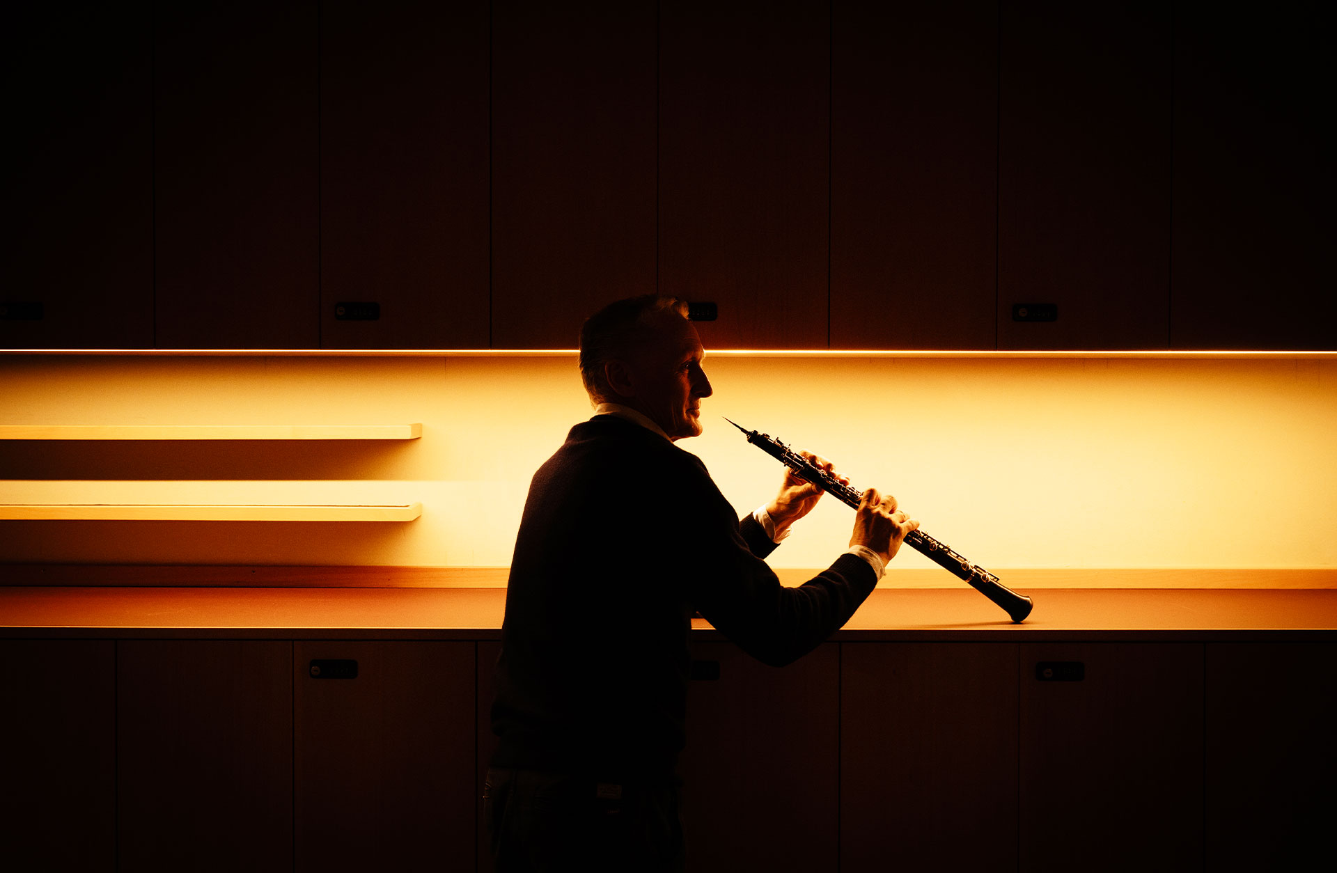 En siluettbild av Mårten Larsson i profil med sin oboe.