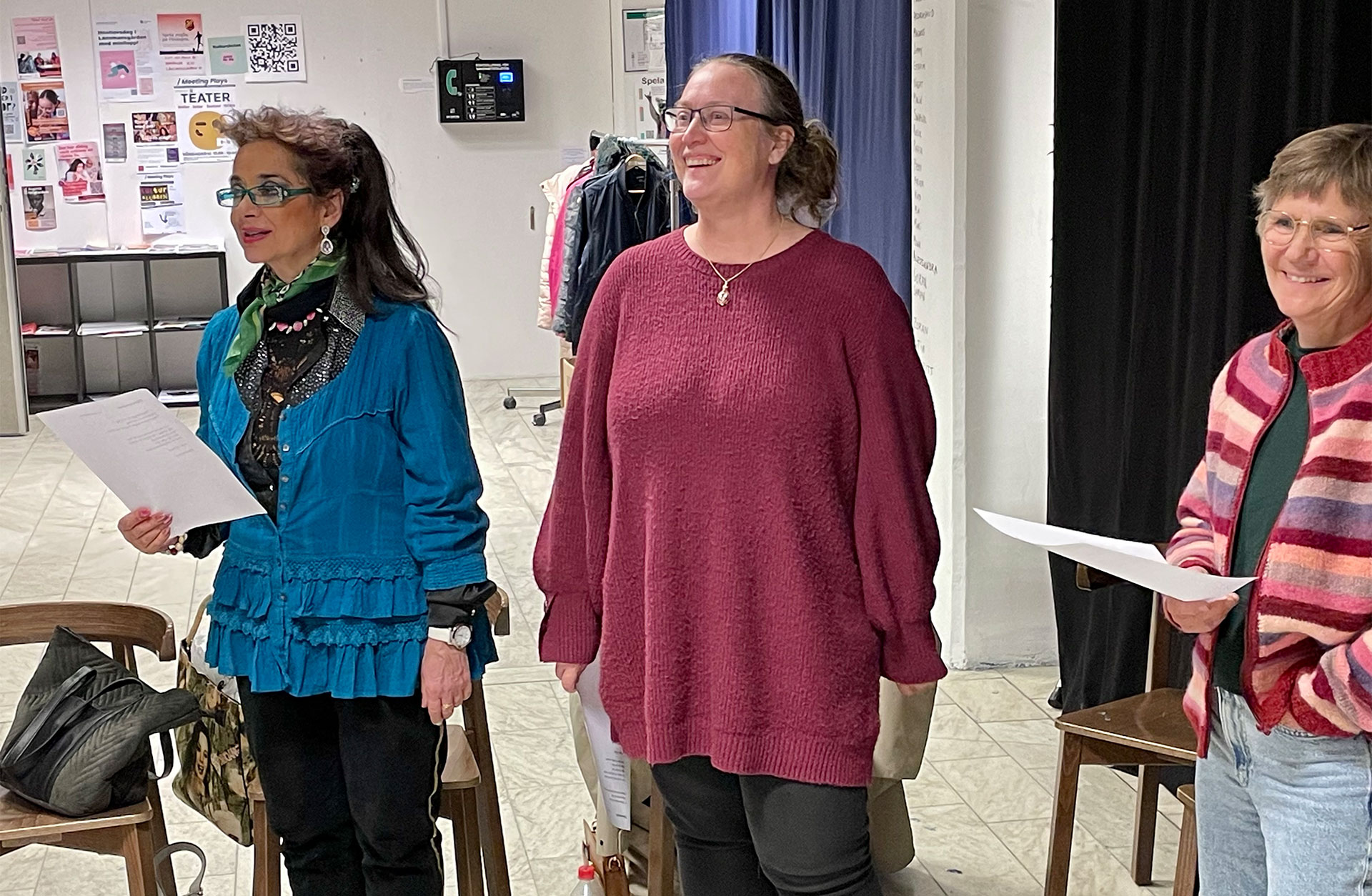 Tre glada medlemmar ur kören håller notpapper i händerna.