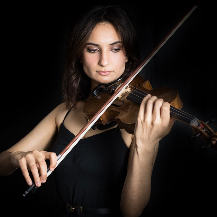Porträttbild när Ava Bahari spelar violin i mörker