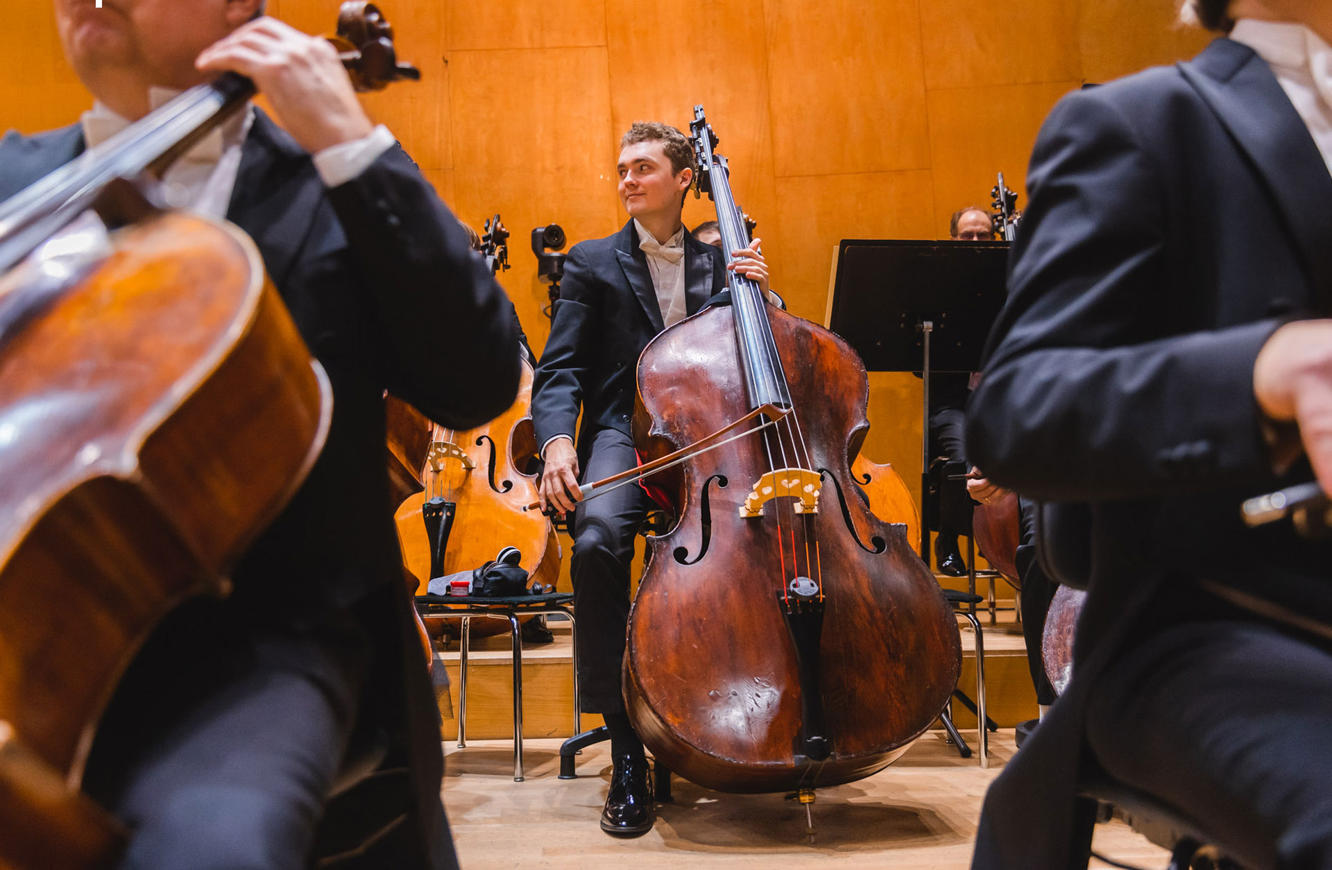 Glad kontrabasist på scenen med blicken åt sidan.