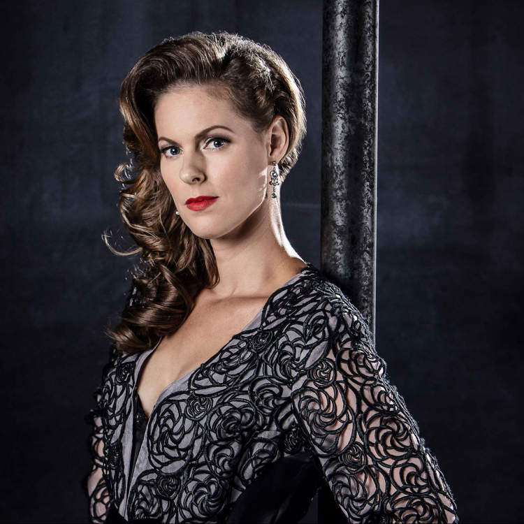 Ida Wiland står mot mörk bakgrund i profil