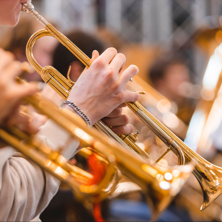 Närbild på händer som spelar trumpet