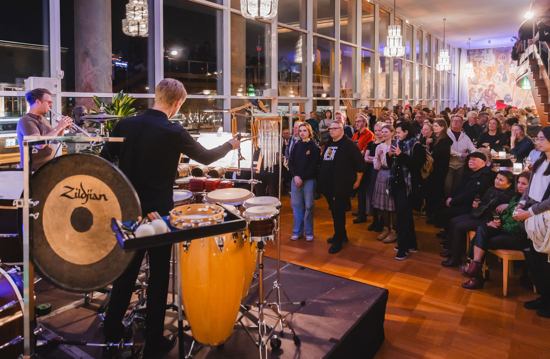 En slagverkare och trumpetare spelar för en publik i götaplatsfoajén.