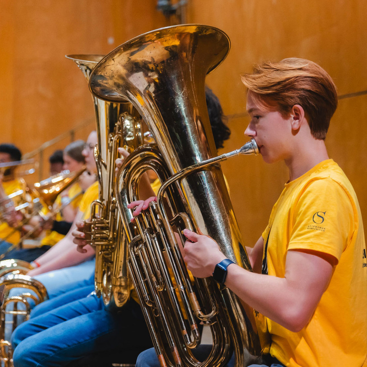 Ung kille spelar tuba.