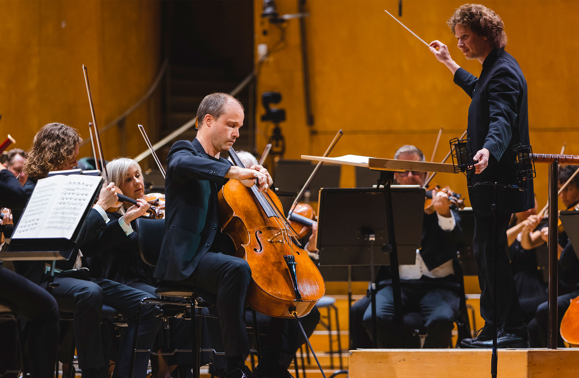Konsertbild där en man spelar cello.