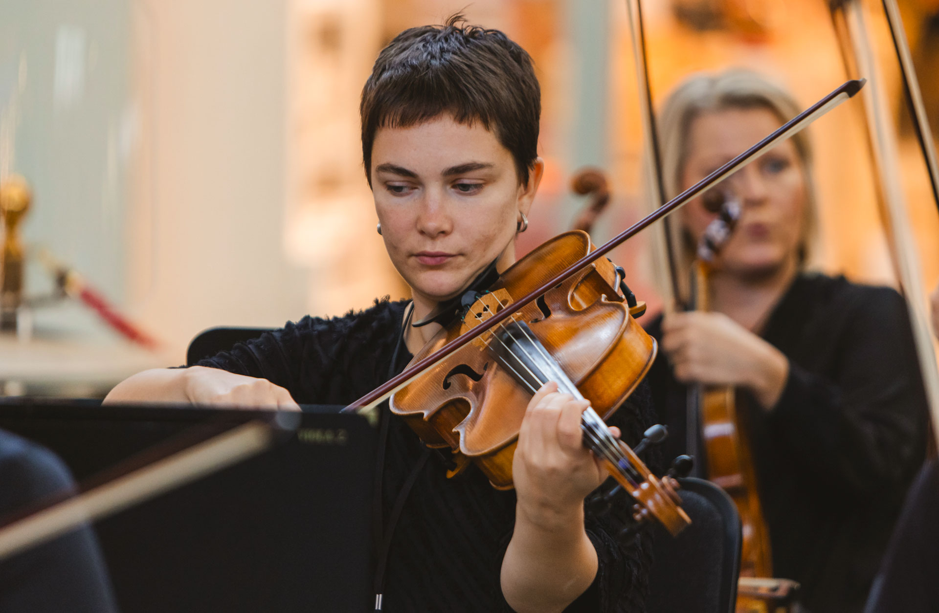 En ung kortklippt kvinna spelar violin.