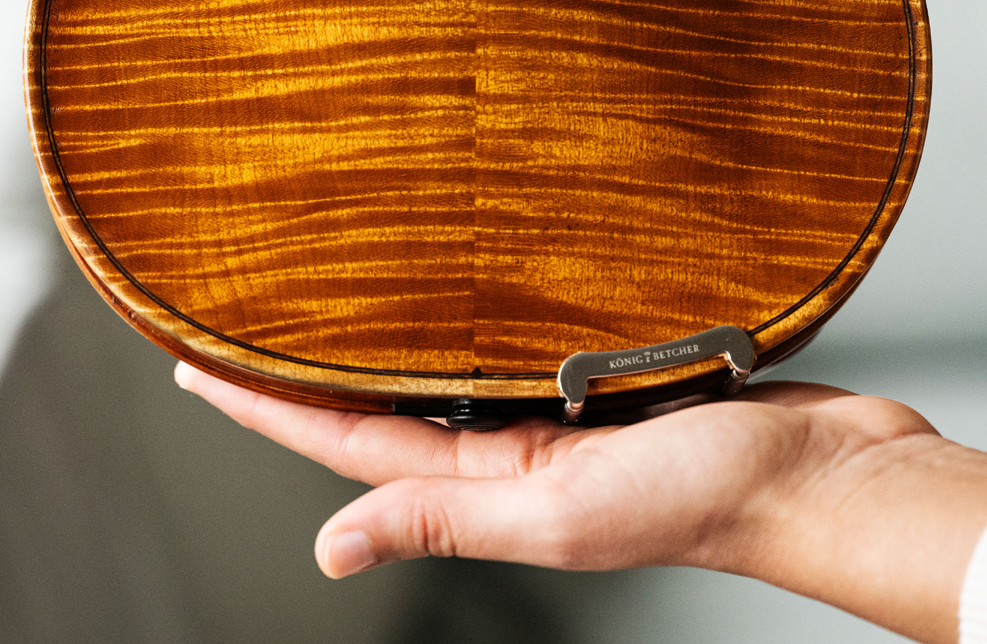 Trädetaljer av en fiol som vilar i en hand.