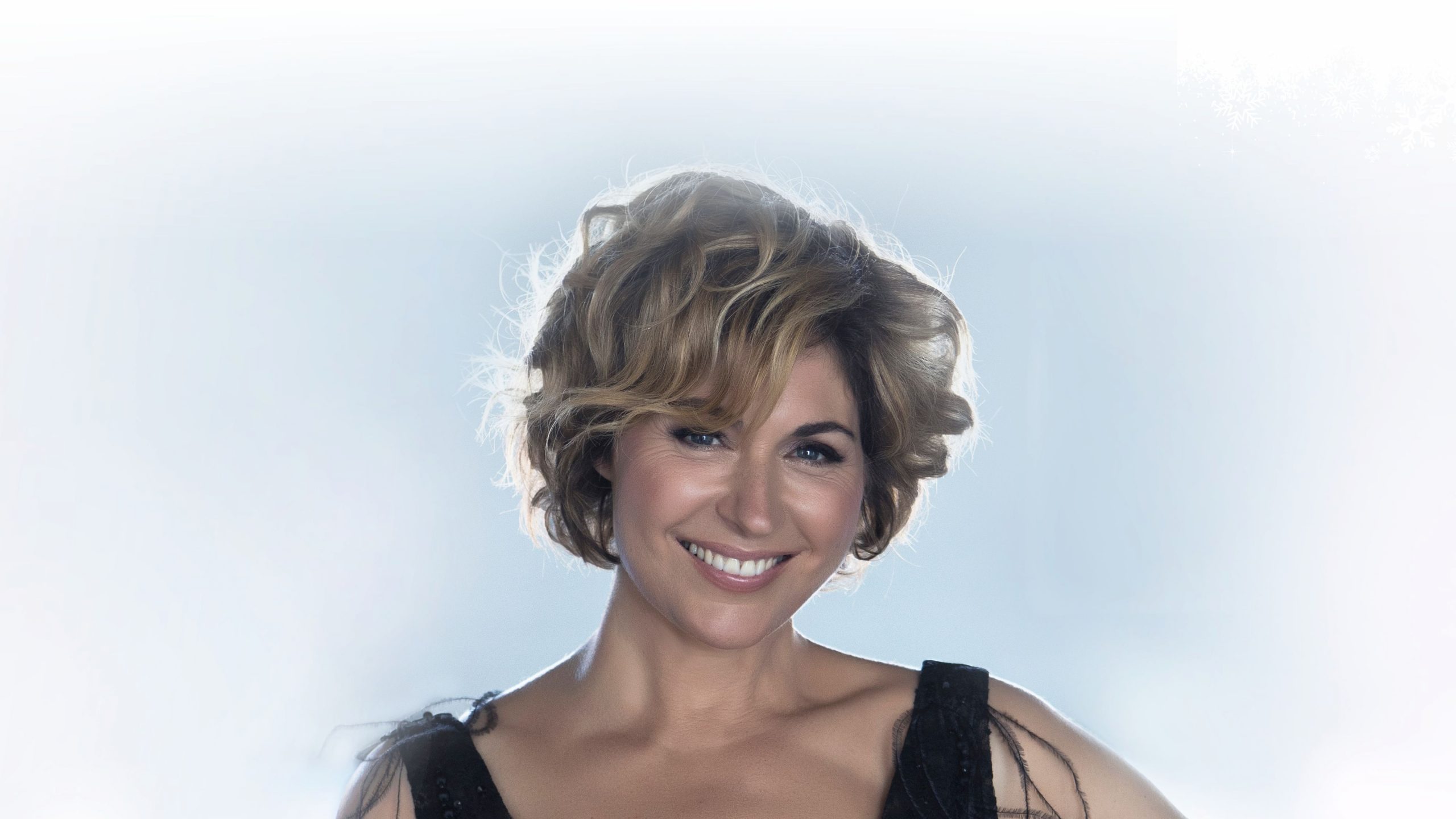 Ett kvinnligt ansikte med kort frisyr framför en ljusblå vägg