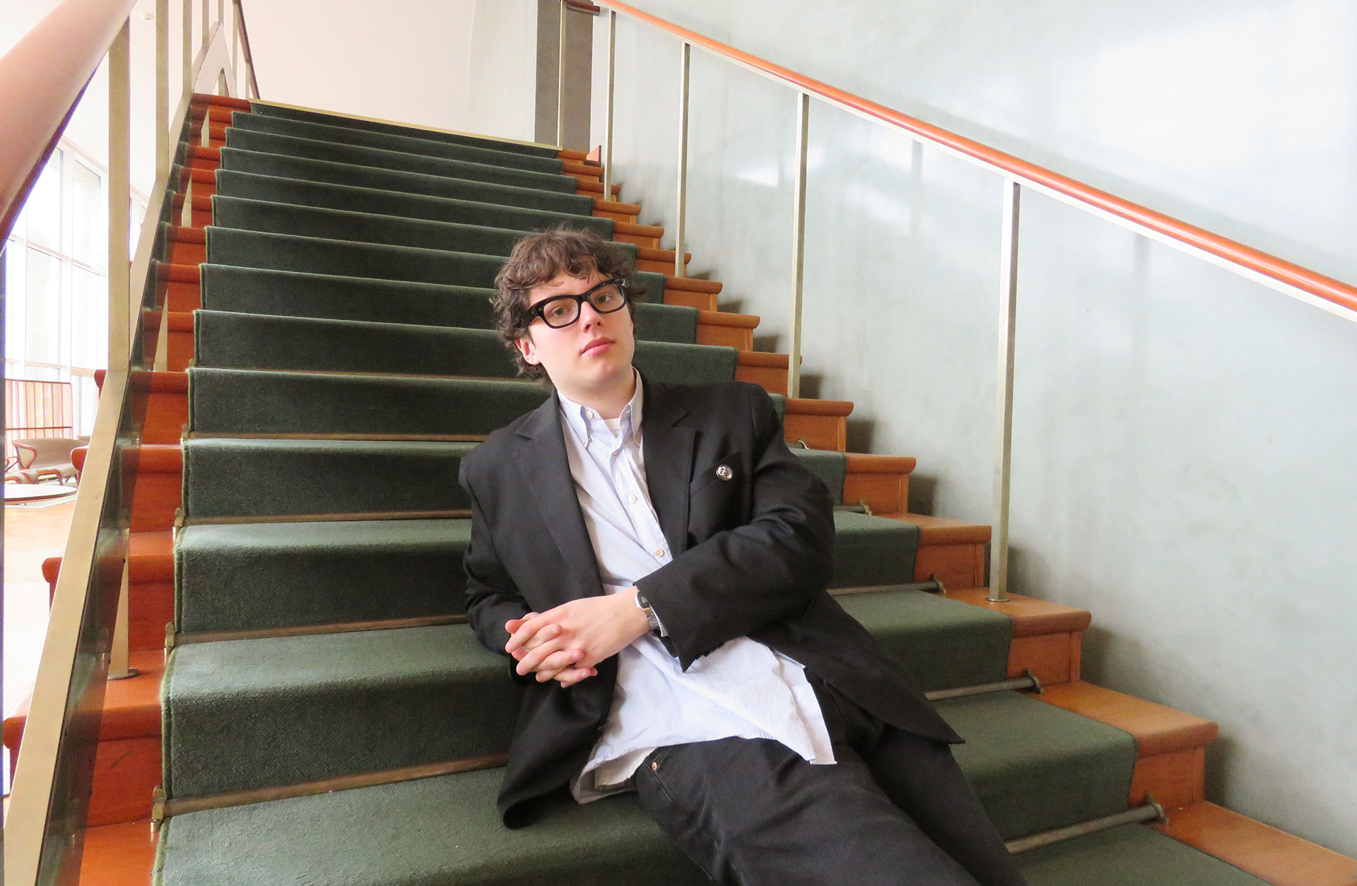 Victor Picaut sträcker ut sig i trappan upp till läktaren i Götaplatsfoajén.