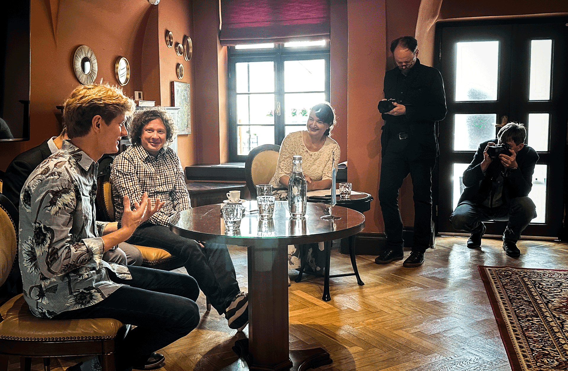 Presskonferens: Jan Lisiecki och Santtu-Matias Rouvali sitter vid ett bord och samtalr med en journalist. Där finns också fotografer.