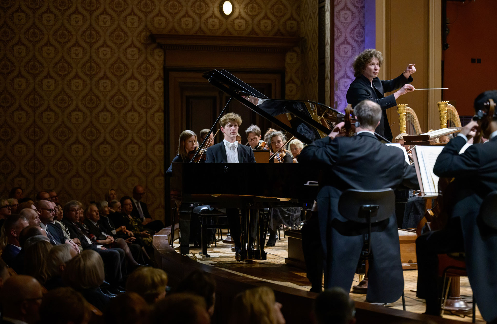Konsertbild där man ser Jan Lisiecki vid flygeln och Santtu-Matias Rouvali dirigerar från pulten.