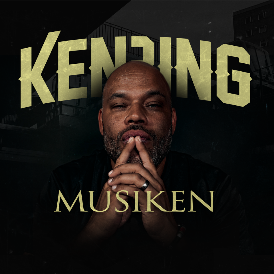 artisten Ken Ring sitter med fingertopparna mot varandra framför munnen. Svart bakgrund.