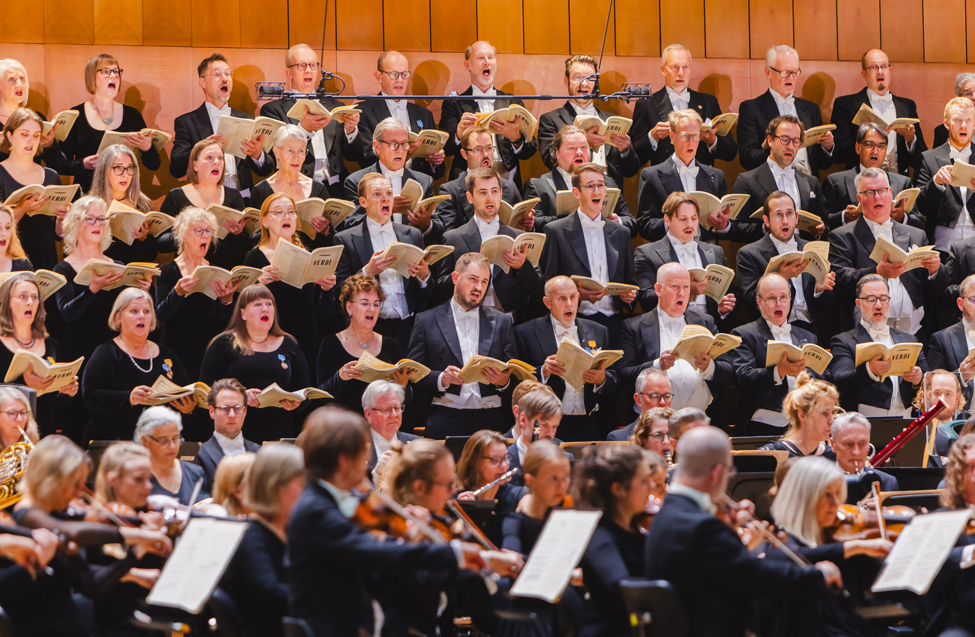 Konsertbild av en kör som sjunger bakom symfoniorkestern.