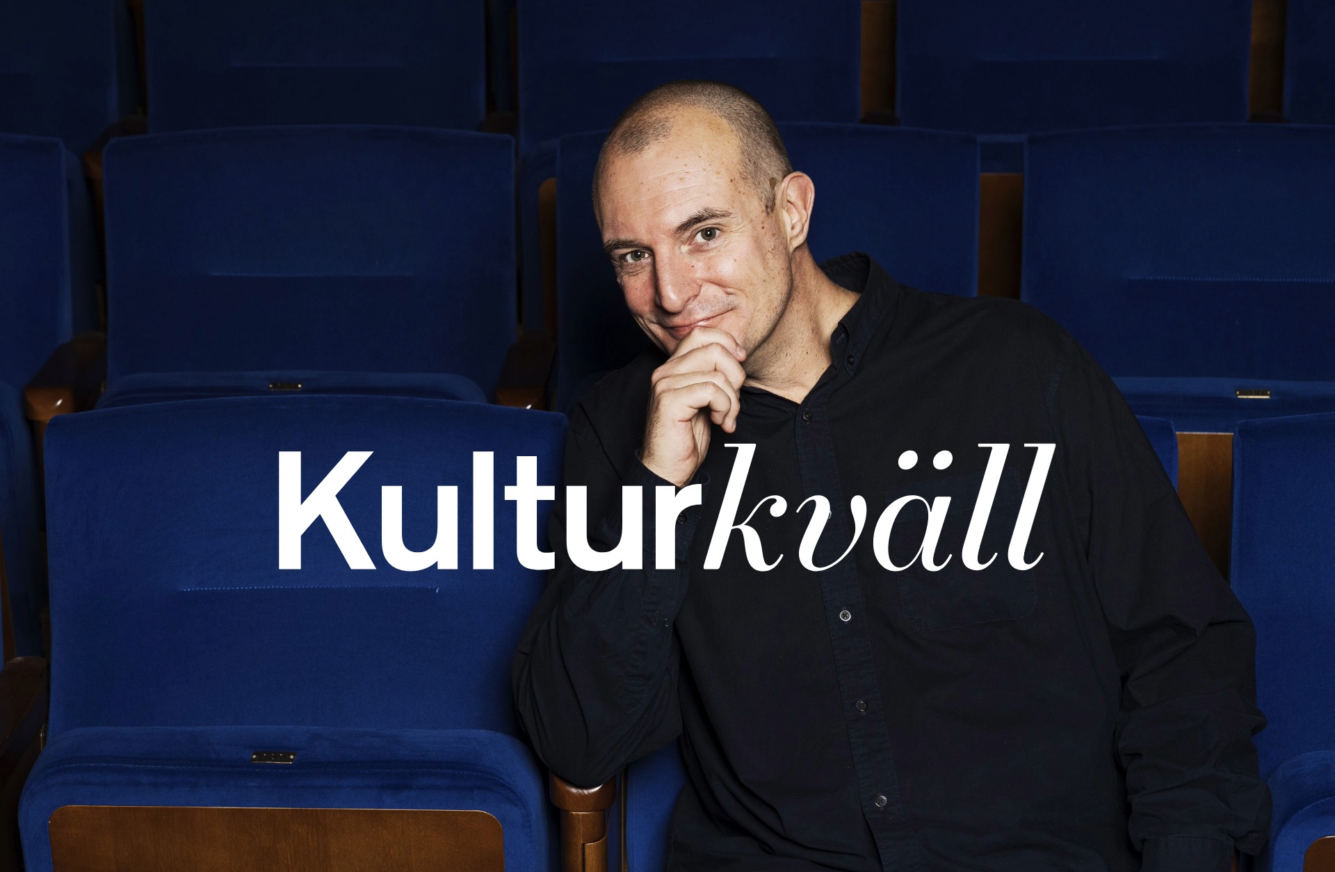 Johan Hilton i ett hav av blå salongsstolar.