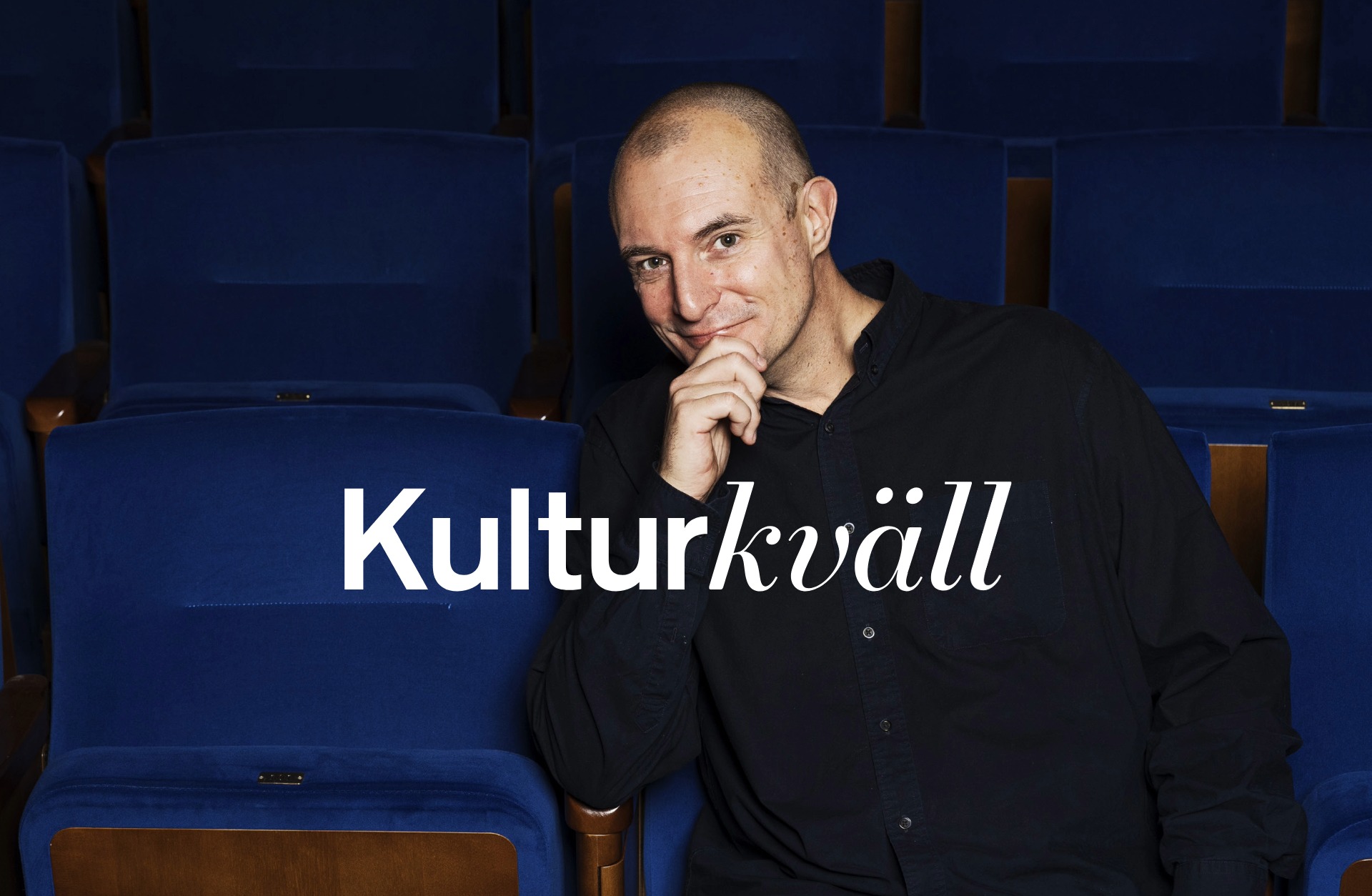 Johan Hilton i ett hav av blå salongsstolar.