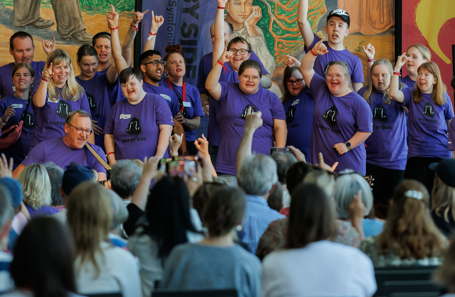 Kören Open Choir med glada miner på scenen.