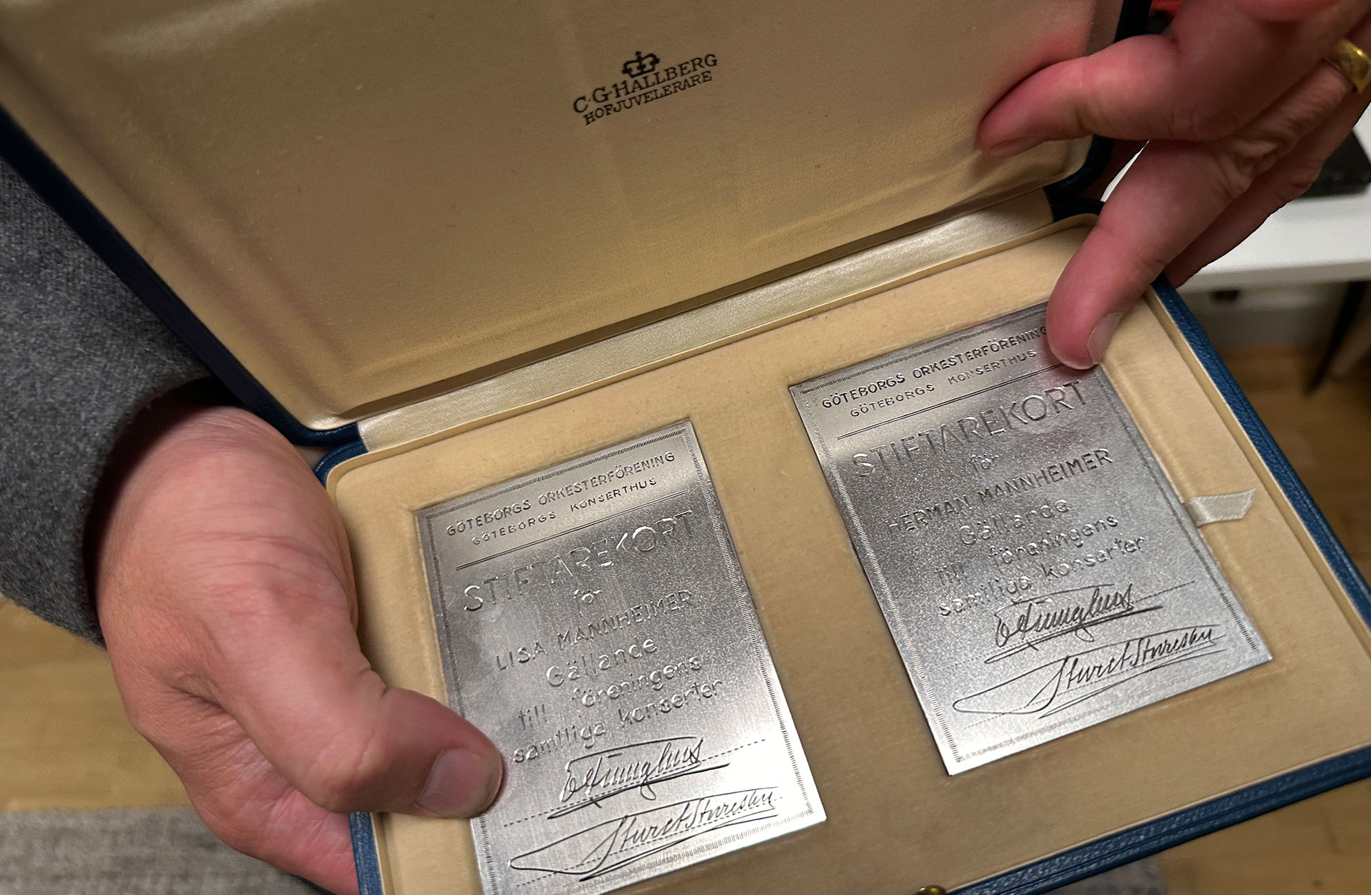 En ask med två fyrkantiga silverplaketter.