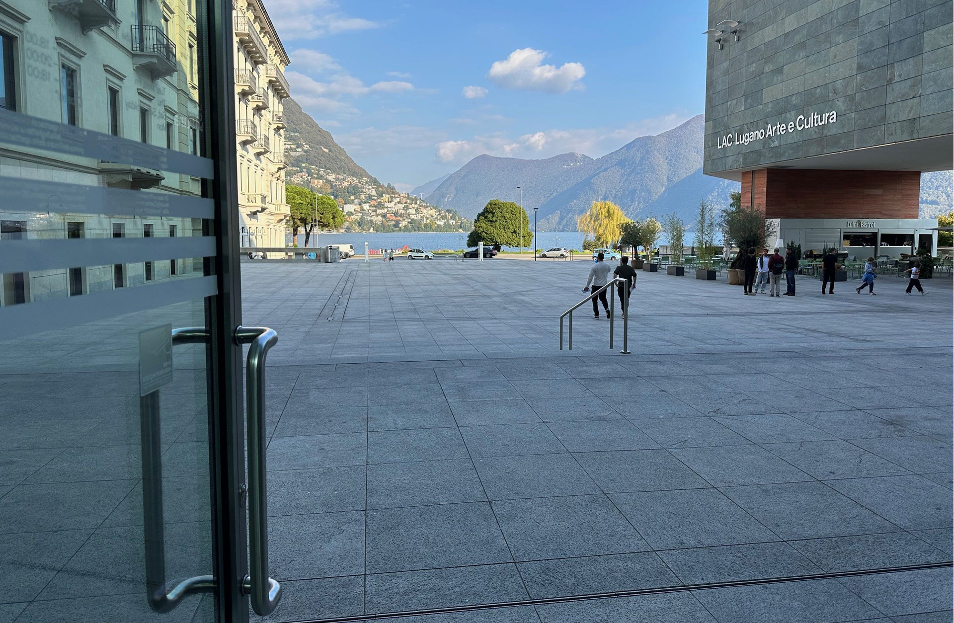 Dörr som leder ut från konserthuset med vacker vy över sjö och bergstoppar.