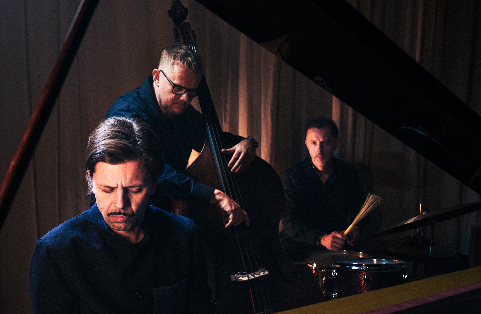 Tre män spelar på var sitt instrument.