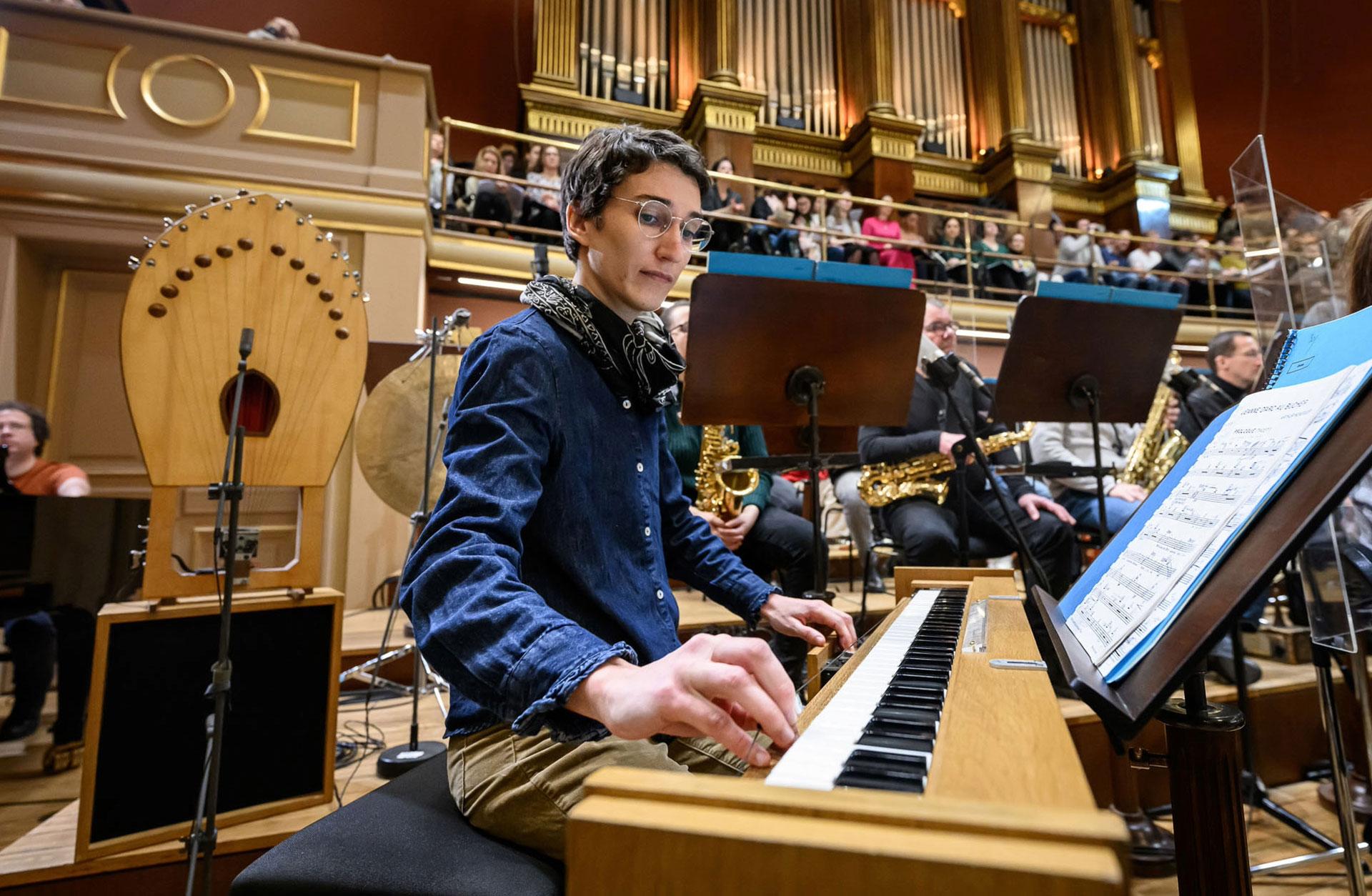 En kvinna sitter vid ett orgels spelbord med händerna på klaviaturet.