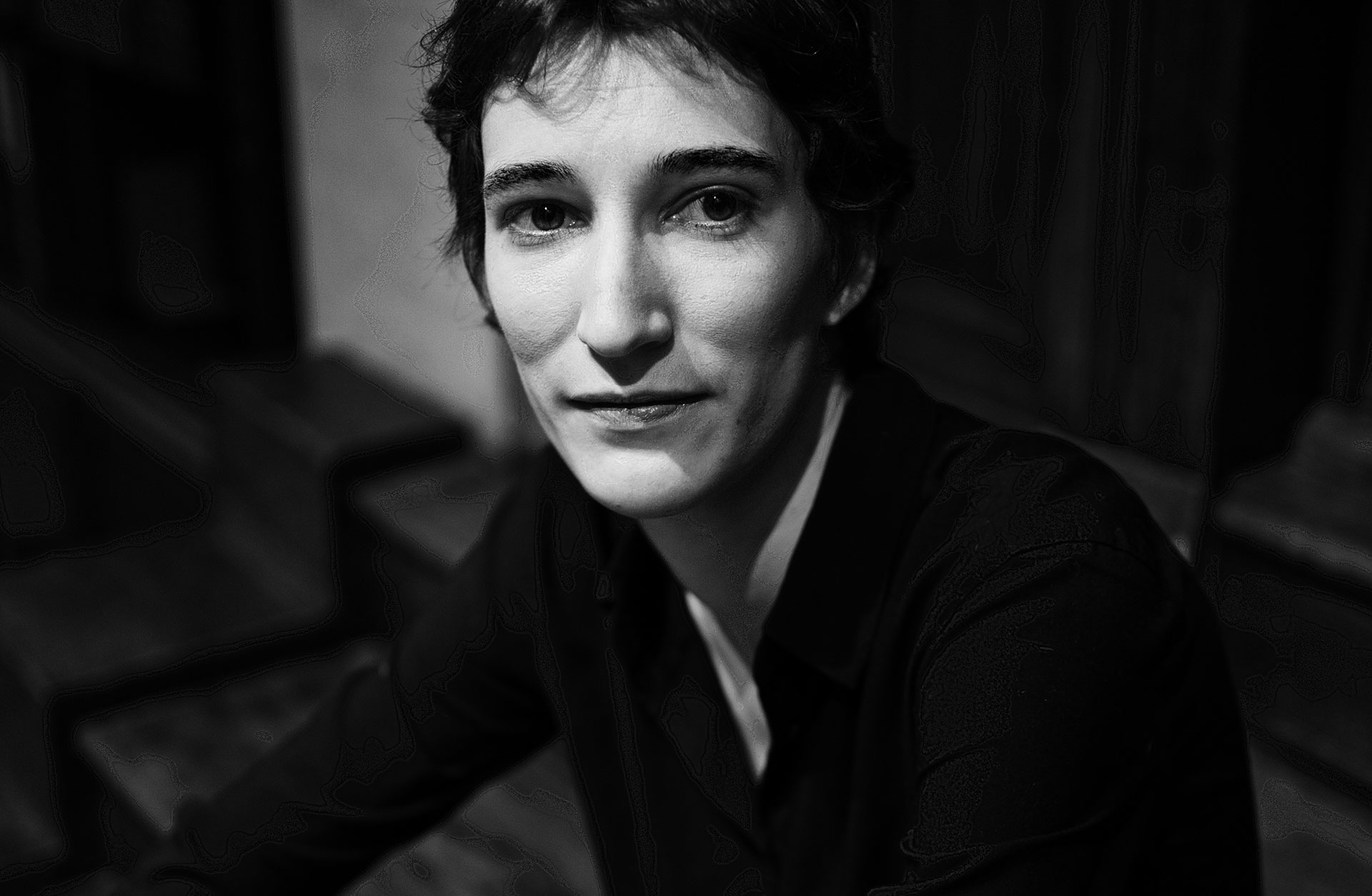 Svartvit bild av en korthårig kvinna som tittar in i kameran.