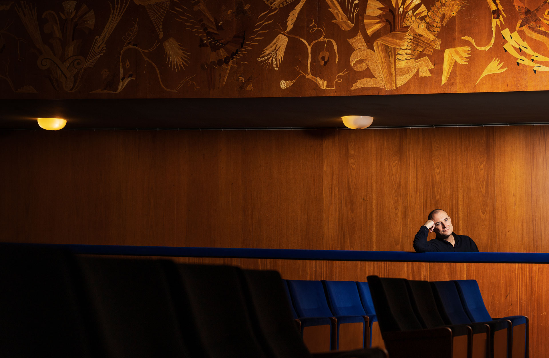 En svartklädd man sitter ensam i en stoplsrad i Stenahammarsalen.