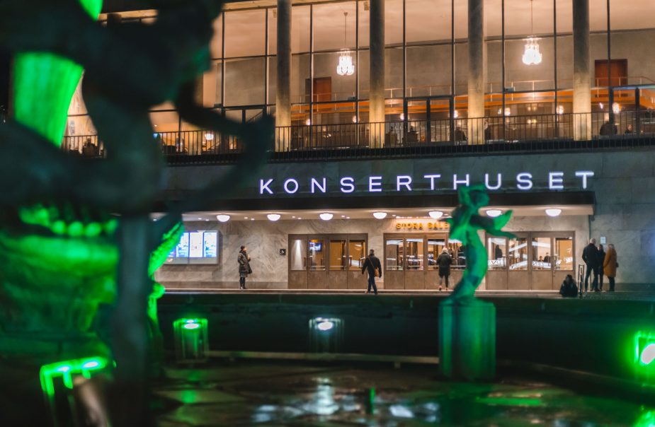 Konserthustes fasad. Grönt ljussatt i fontänen utanför.