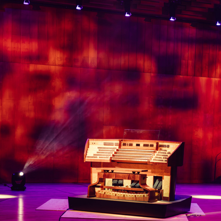 En orgel mot rödrutigt ljussatt bakgrund.