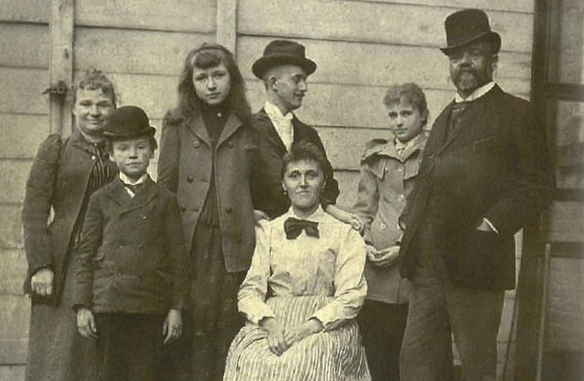 Ett gammalt svartvitt foto av en grupp människor i olika åldrar.