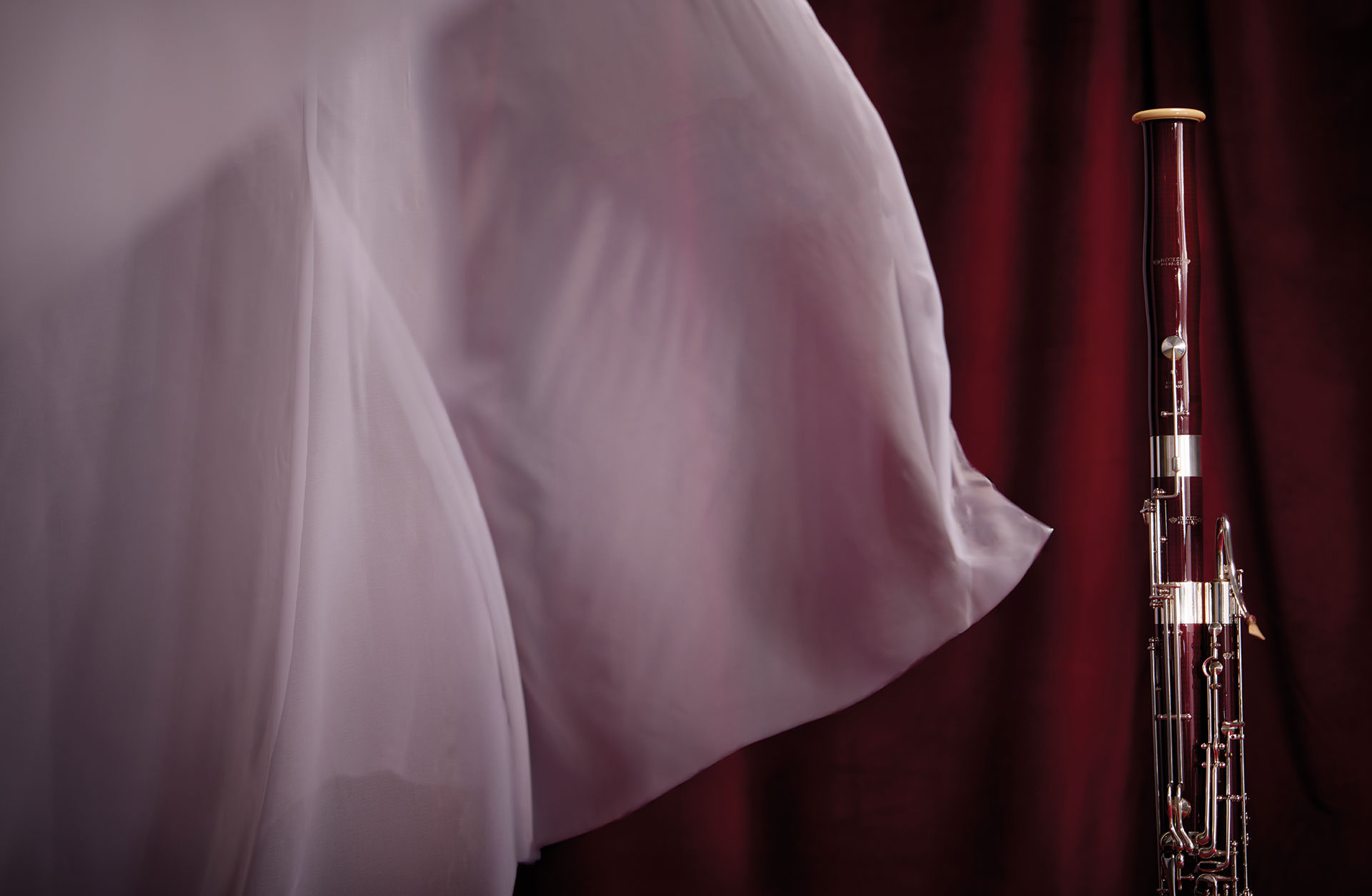 En fagott fotad mot röd bakgrund med böljande vita tyger.