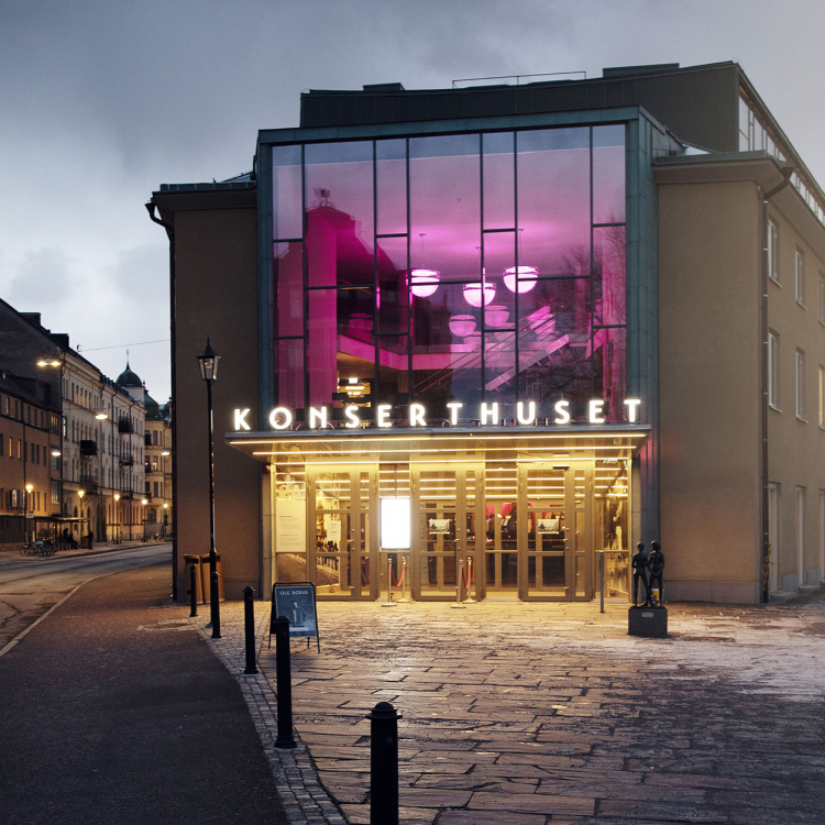 Örebro Konserthus entrésida från utsidan med stämningsfullt ljus.